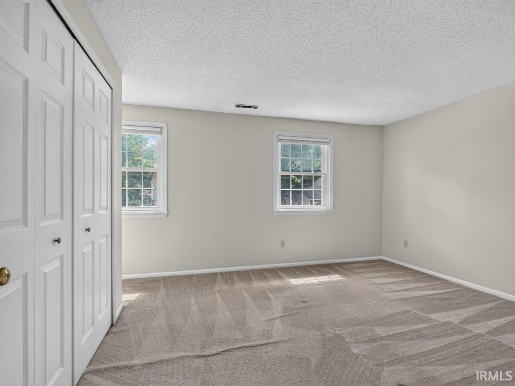 Neutral wall tones, two windows with white trim, and bi-fold closet doors