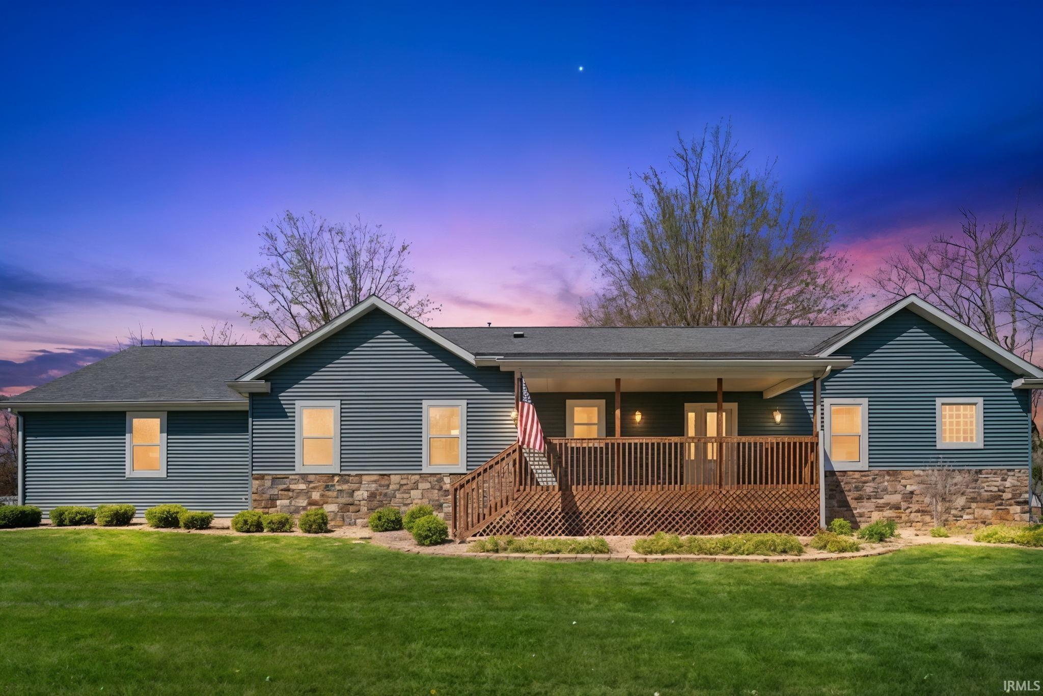 Ranch-style exterior with blue siding and stone veneer accents