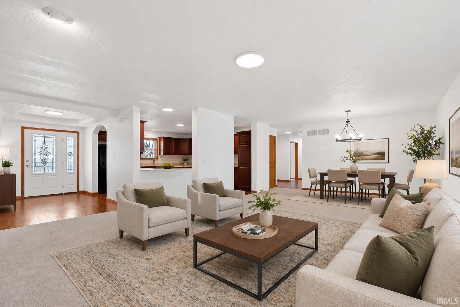 Spacious open-concept interior featuring light-colored walls, recessed lighting, and wood-finish flooring