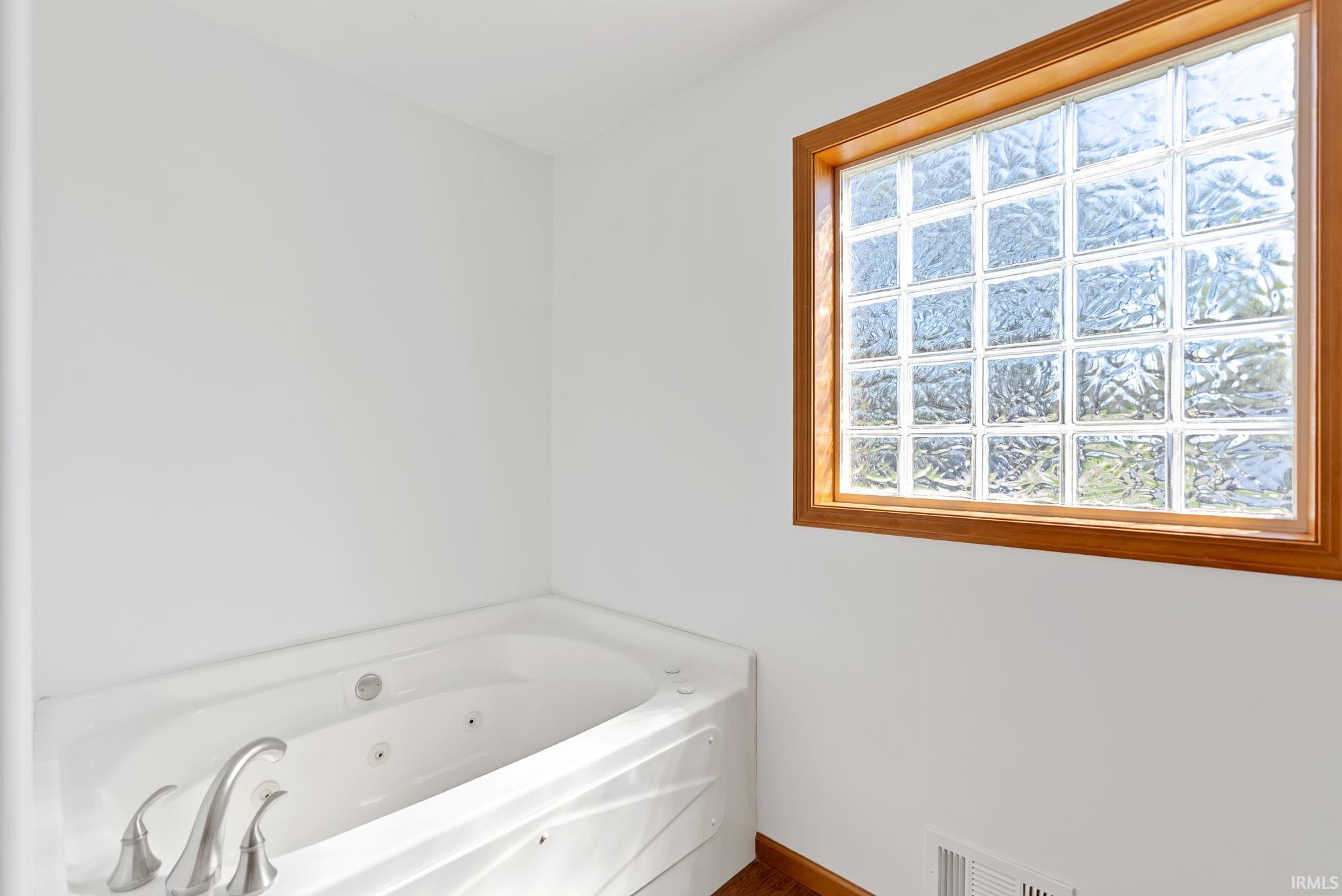 Built-in soaking tub with brushed nickel fixtures and a jetted interior