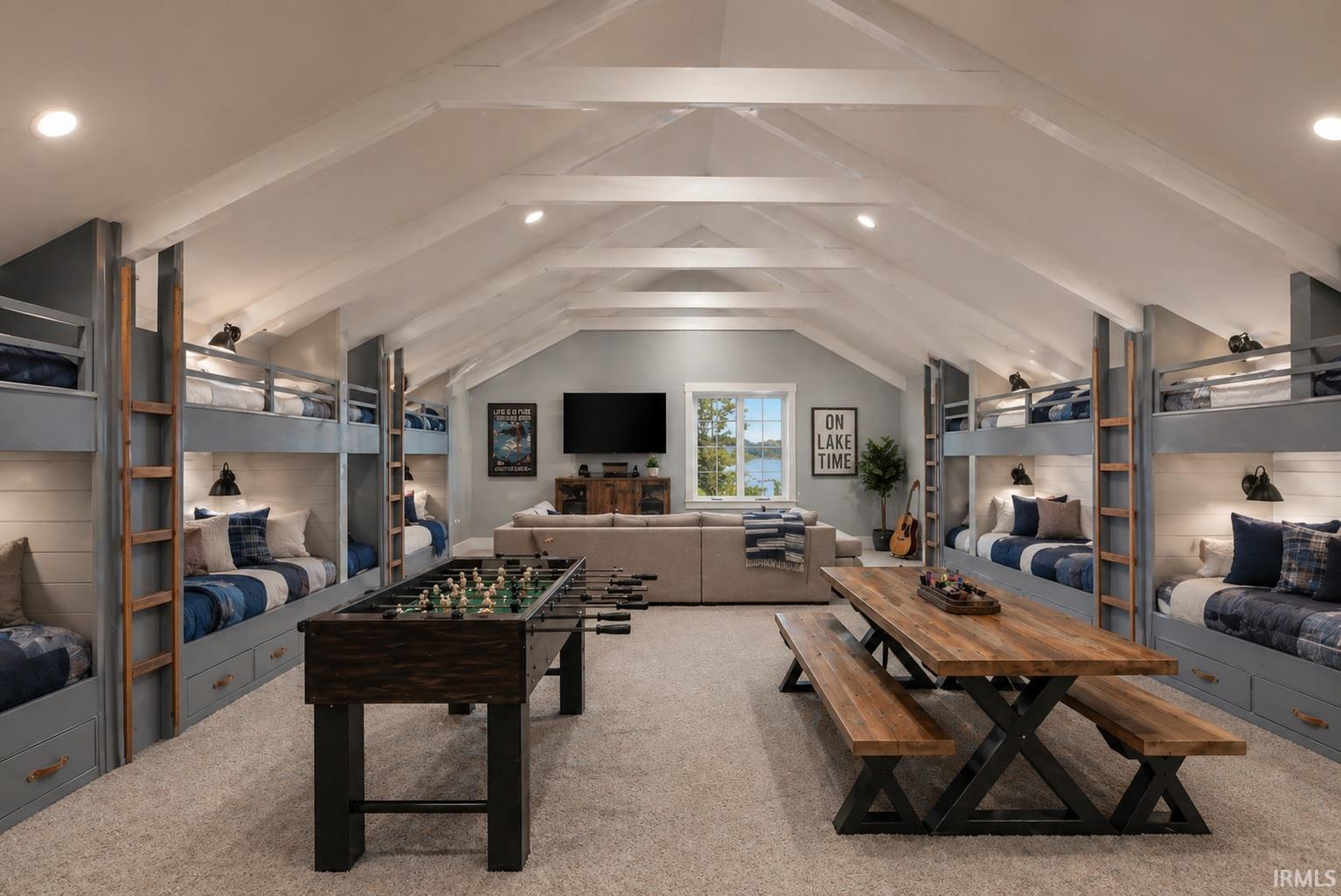 Expansive loft space featuring a vaulted ceiling with exposed beams