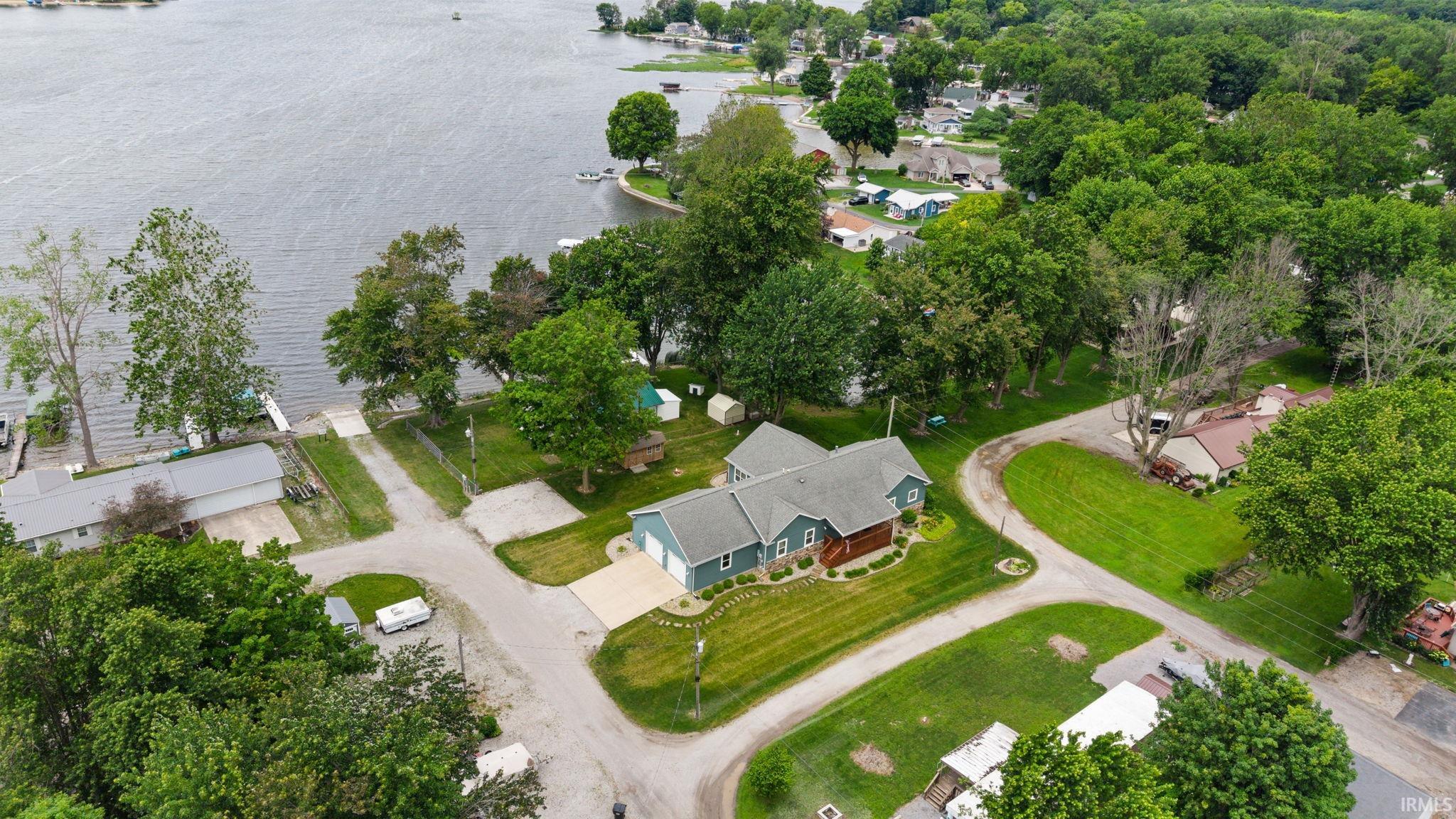 Waterfront property with mature trees, a boat launch, and a private dock