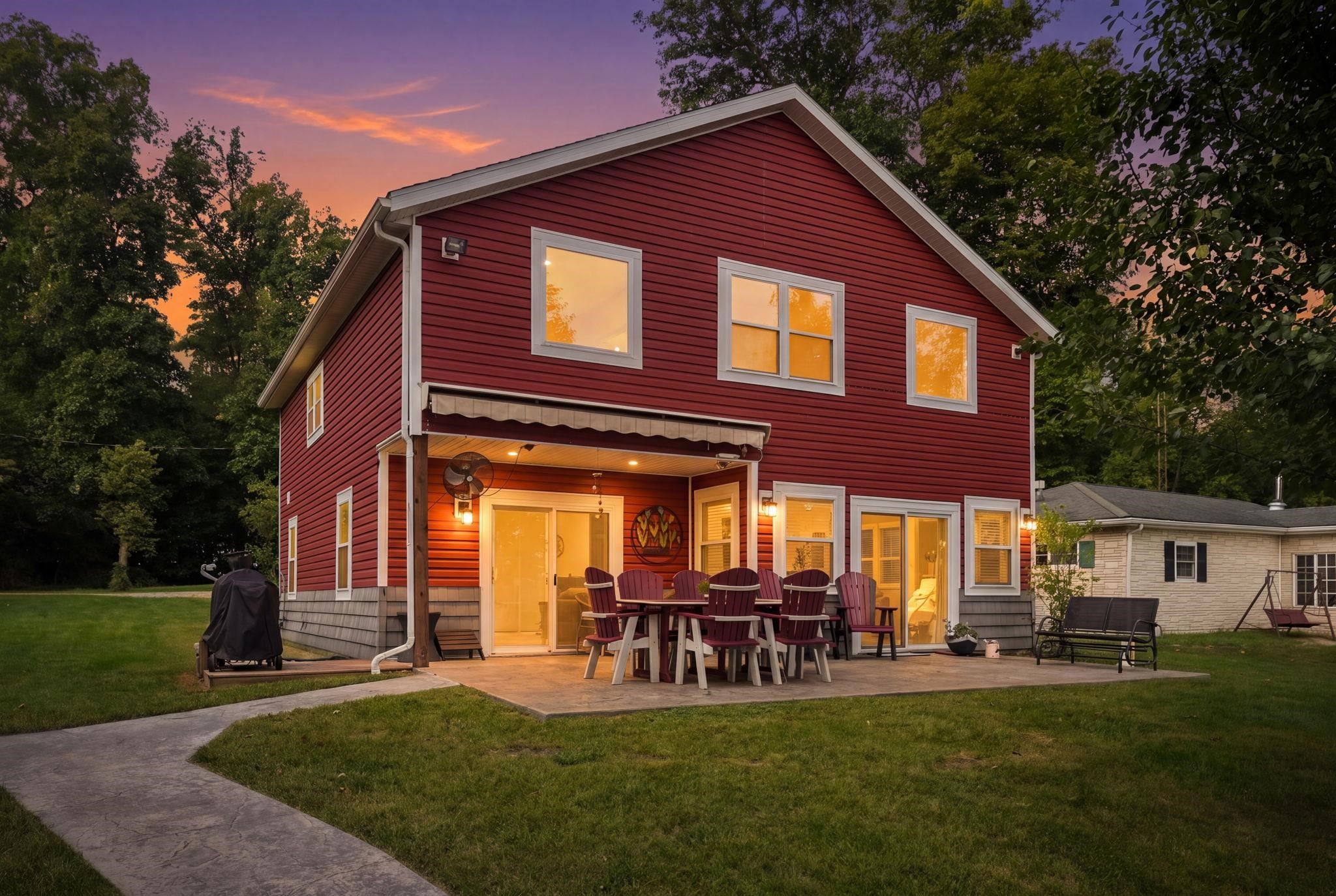 Red siding exterior with white window trim and a covered patio
