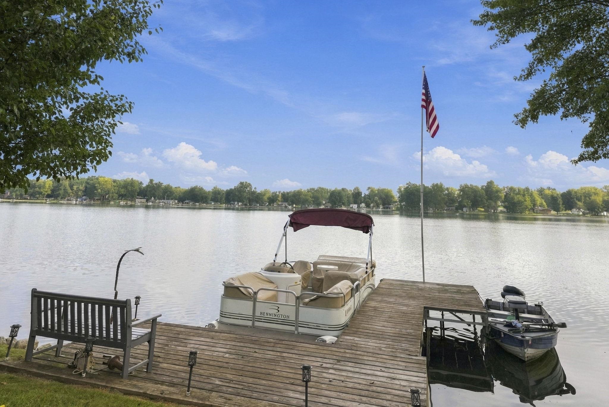 Lakefront property featuring a private wooden dock and expansive water frontage
