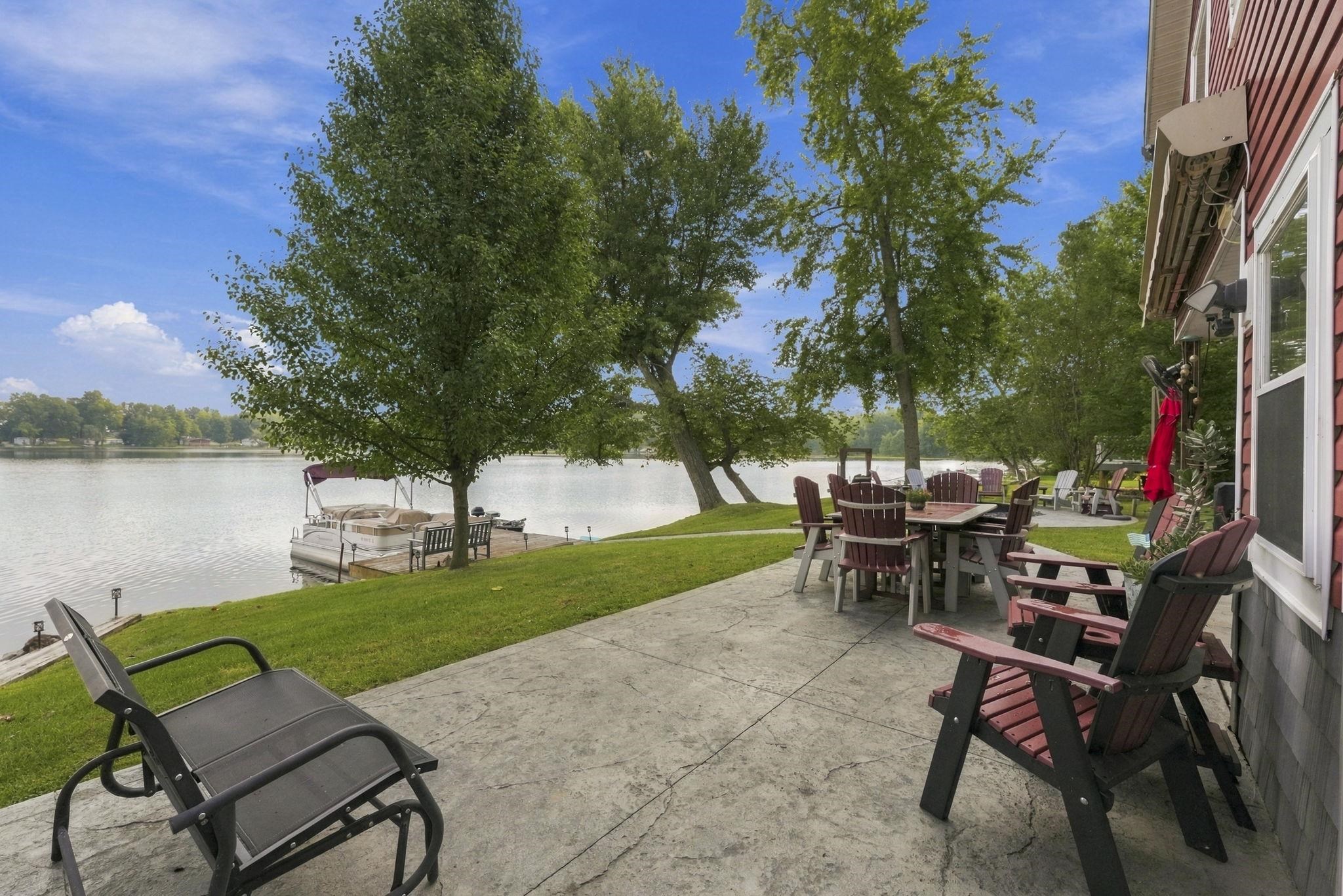 Stamped concrete patio, mature trees, manicured lawn, waterside property, private boat dock