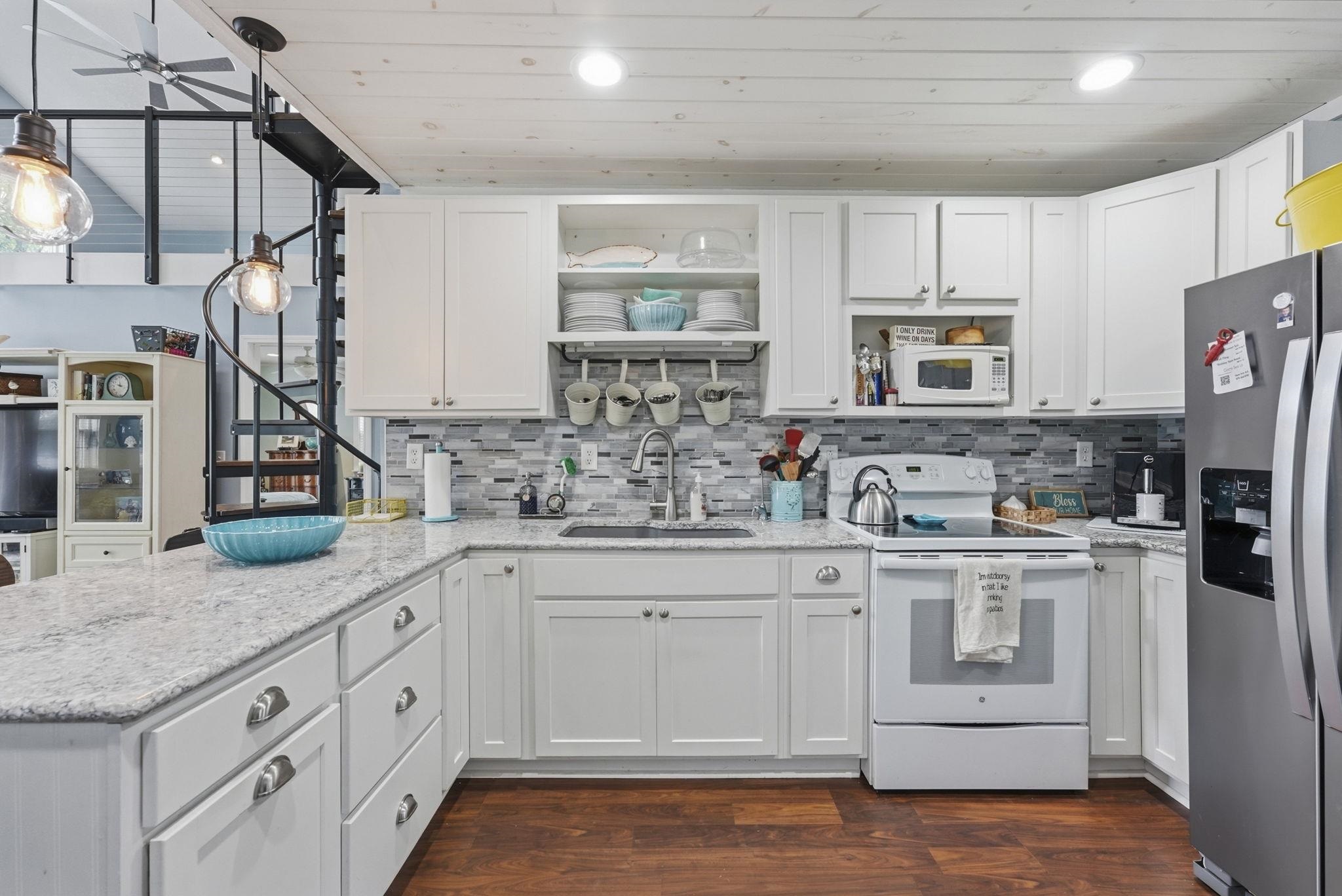 Kitchen featuring white cabinetry, stone countertops, stainless steel refrigerator, white electric range, and wood-finish flooring