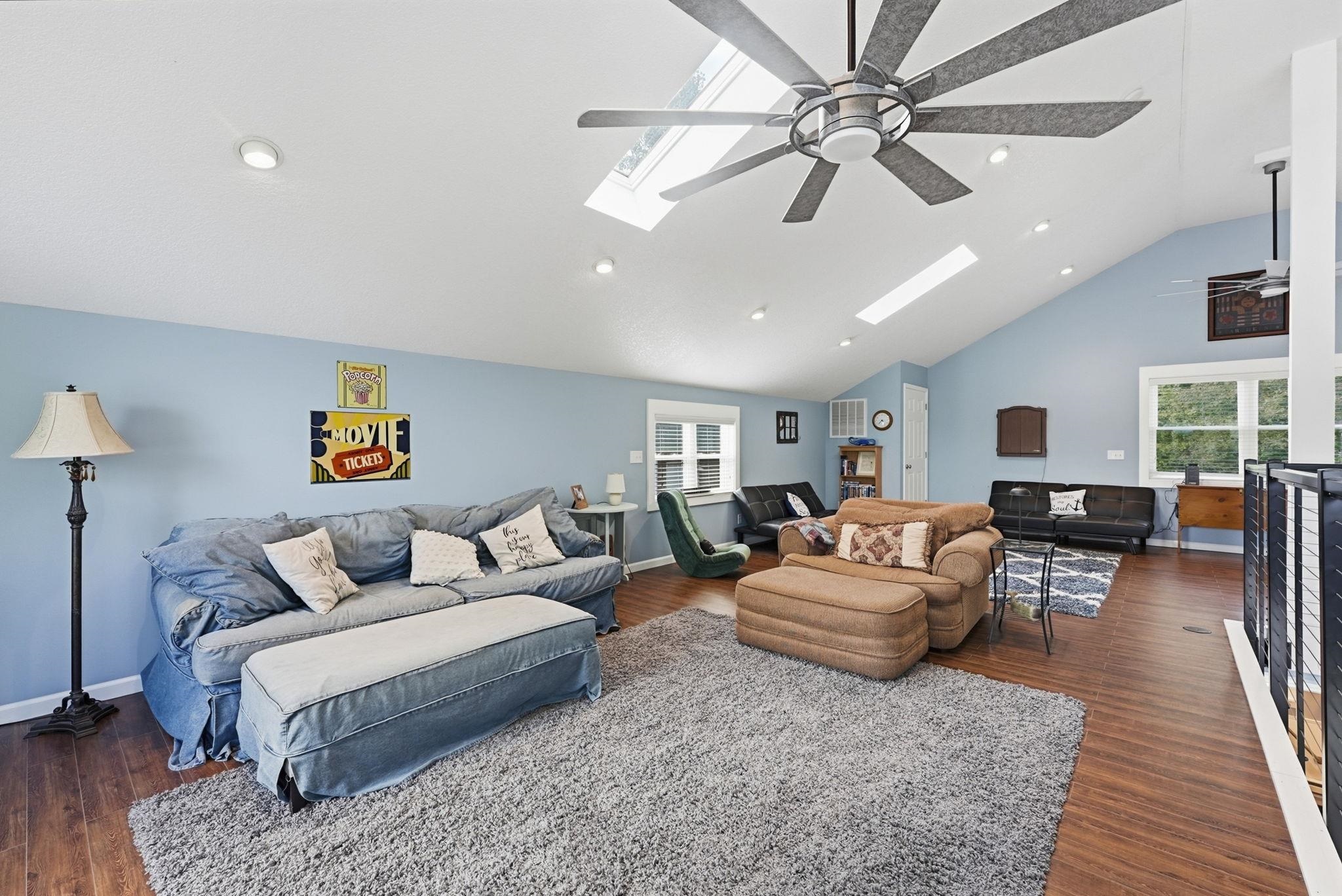 Vaulted ceiling featuring skylights, recessed lighting, and a large ceiling fan