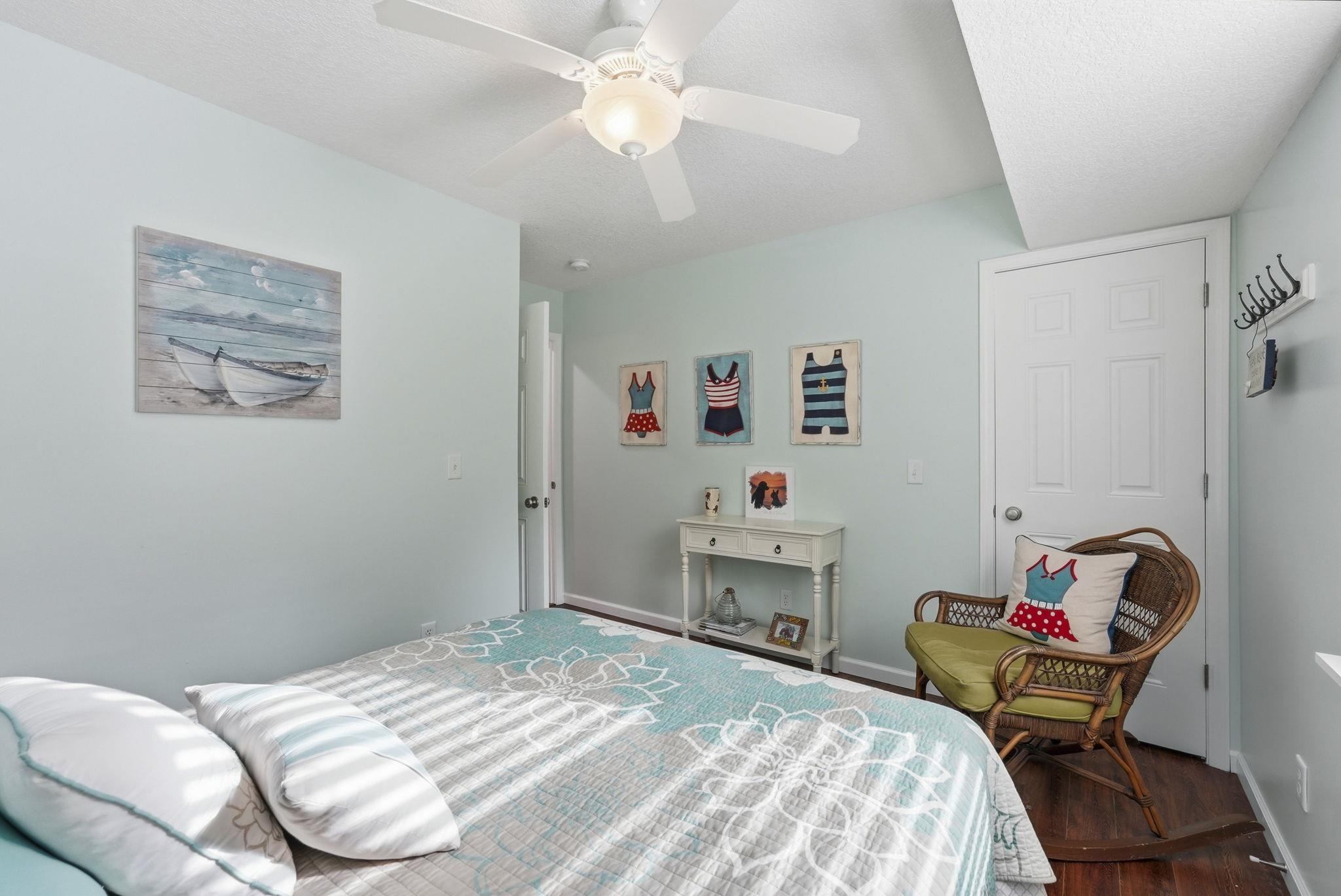 Ceiling fan with integrated lighting, wood-finish flooring, and light-toned walls