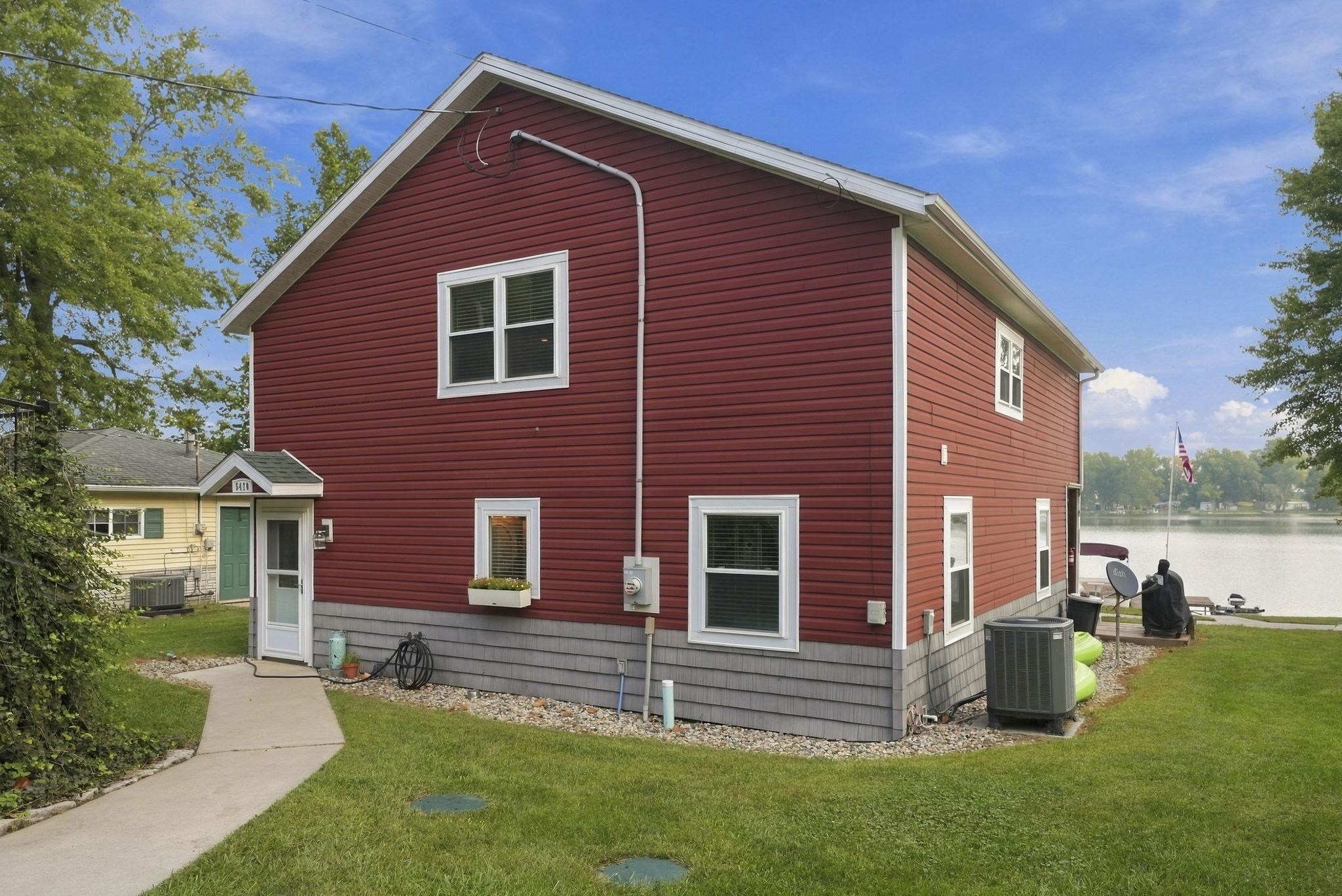 Red siding exterior with white trim windows and a gray shingled foundation
