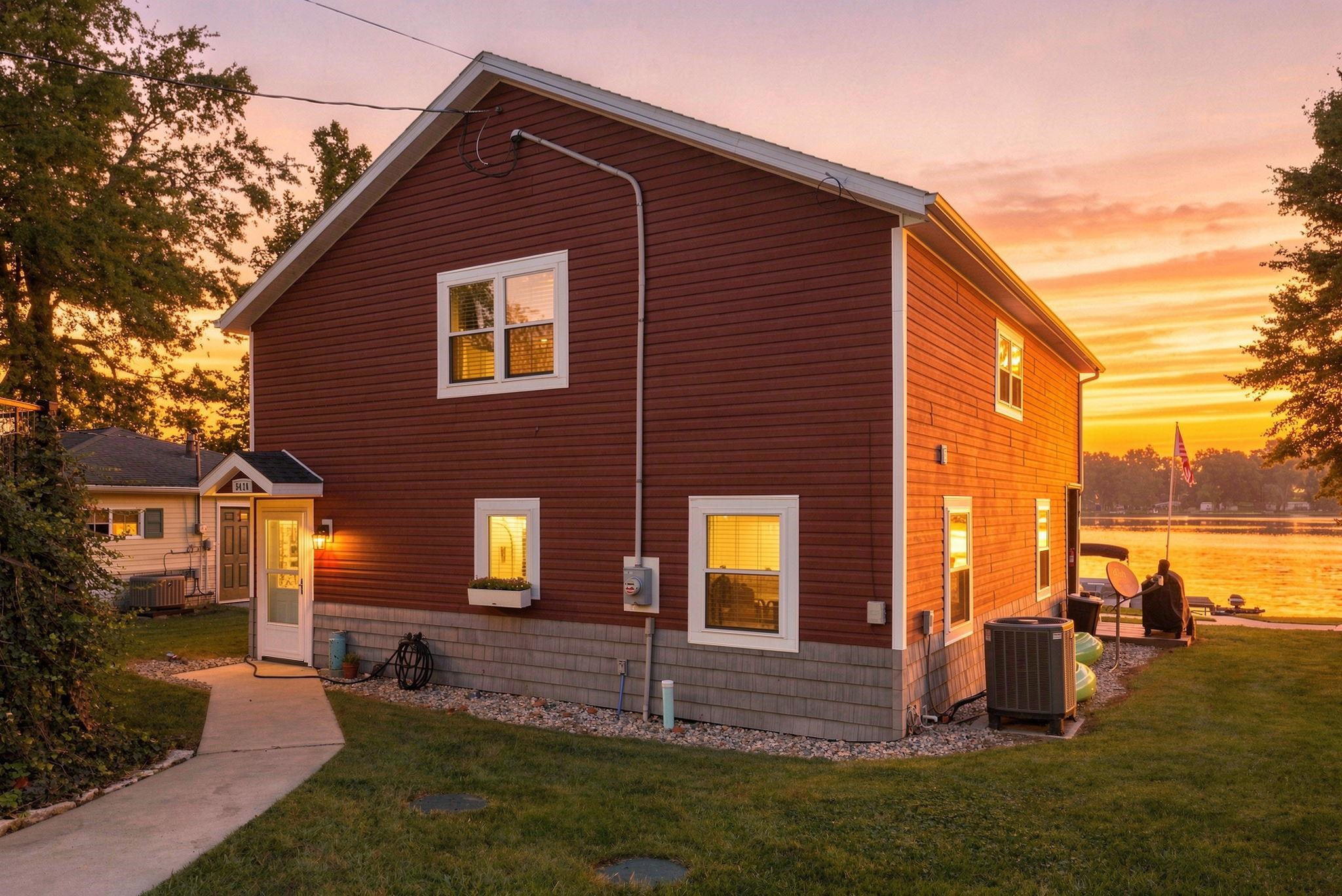 Red siding exterior with white trim windows and a stone veneer foundation