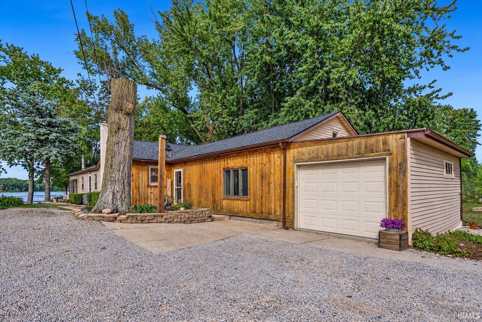 Exterior featuring wood paneling, siding, and a white entry door