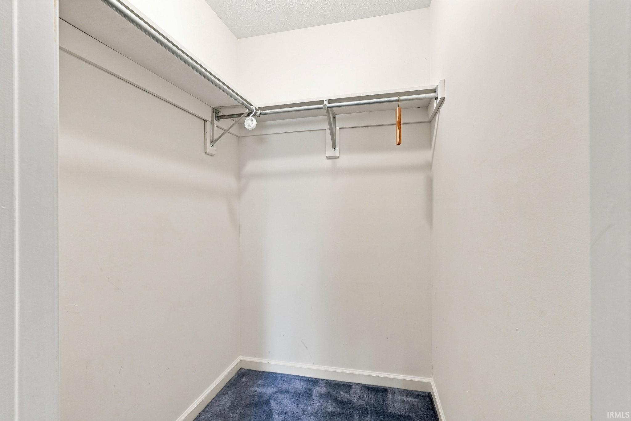 Built-in shelving and hanging rods within a closet space