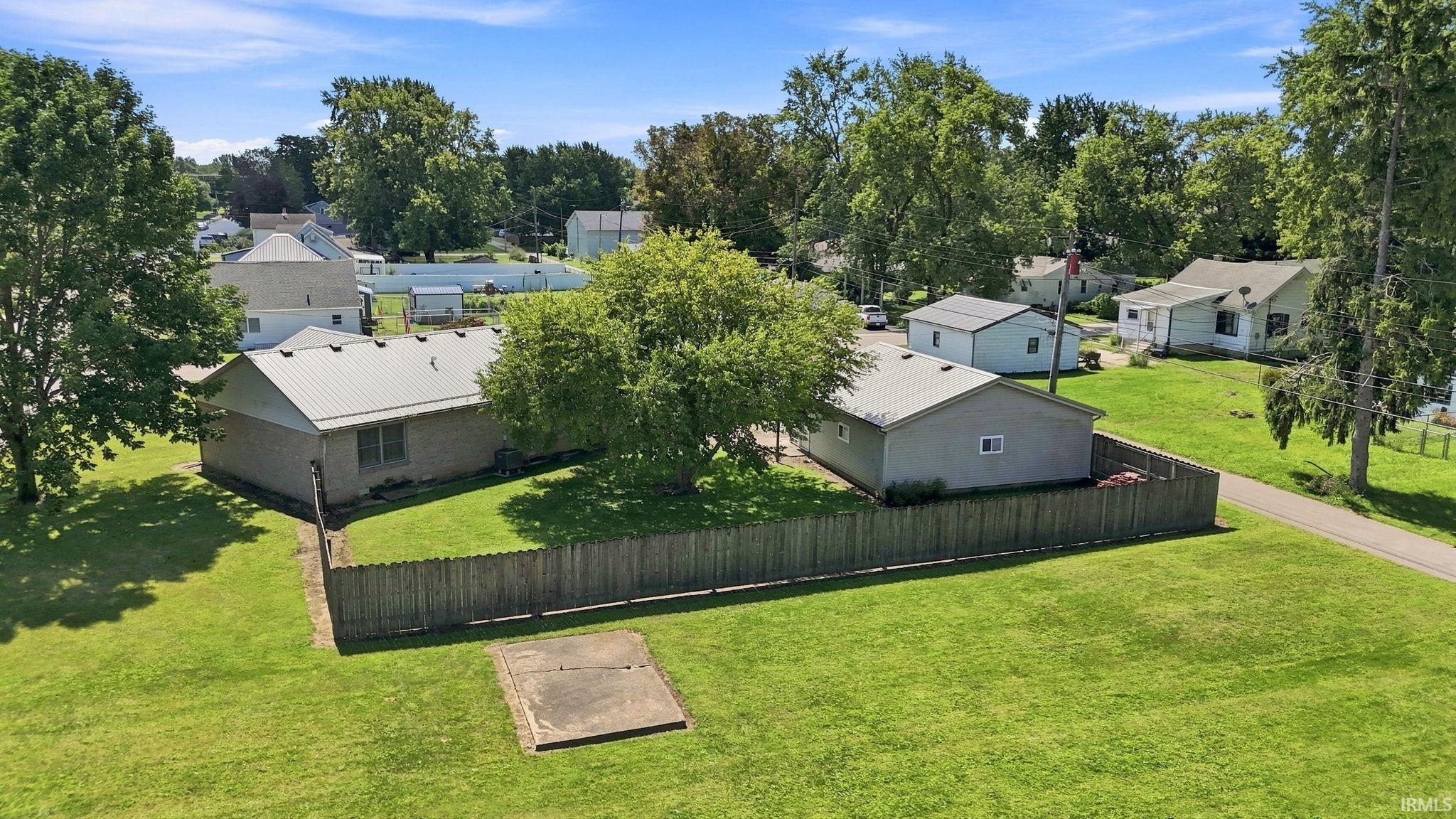 Expansive green lawn, fenced perimeter, and mature trees