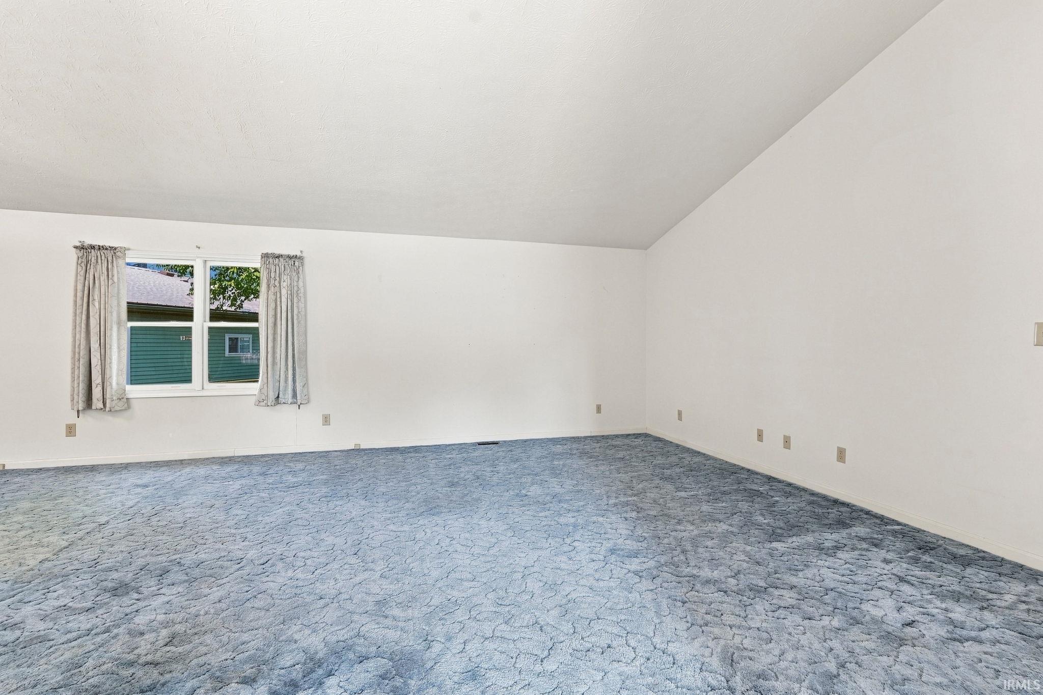 Vaulted ceiling and light blue patterned carpeting