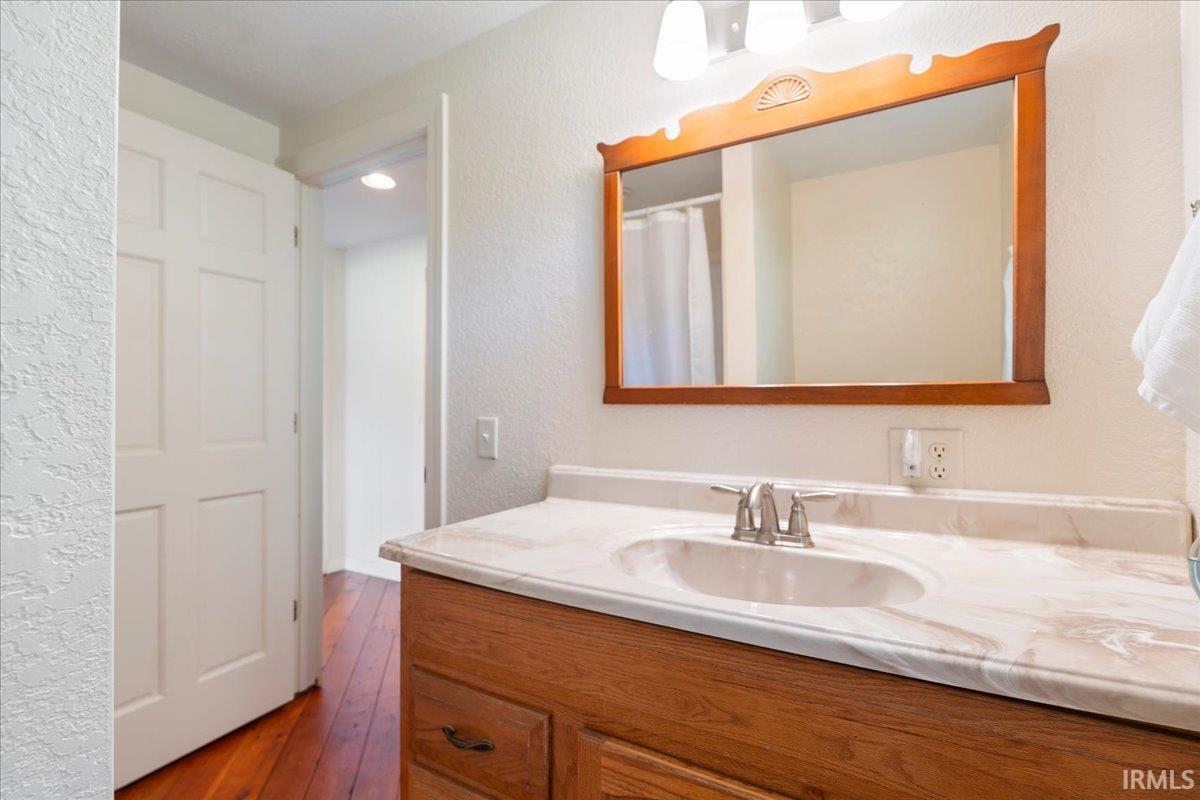 Wood-finish vanity with an integrated basin, chrome-finish faucet, and coordinating wood-framed mirror