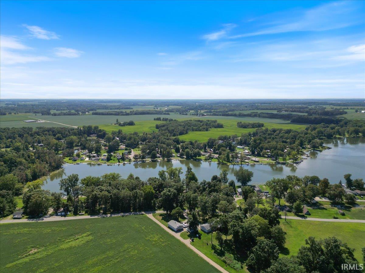 Lakeside community with extensive tree coverage and surrounding agricultural fields