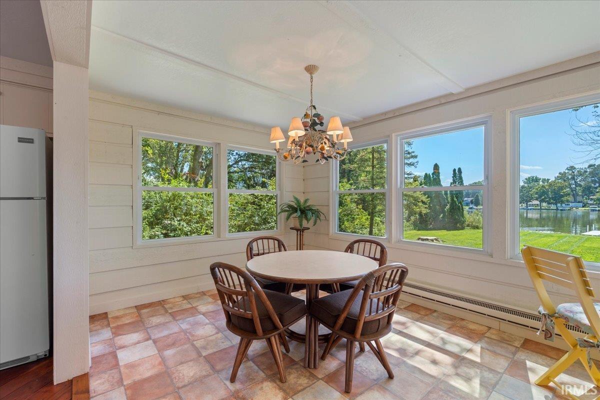 Sunroom with multiple windows, tile flooring, and a chandelier