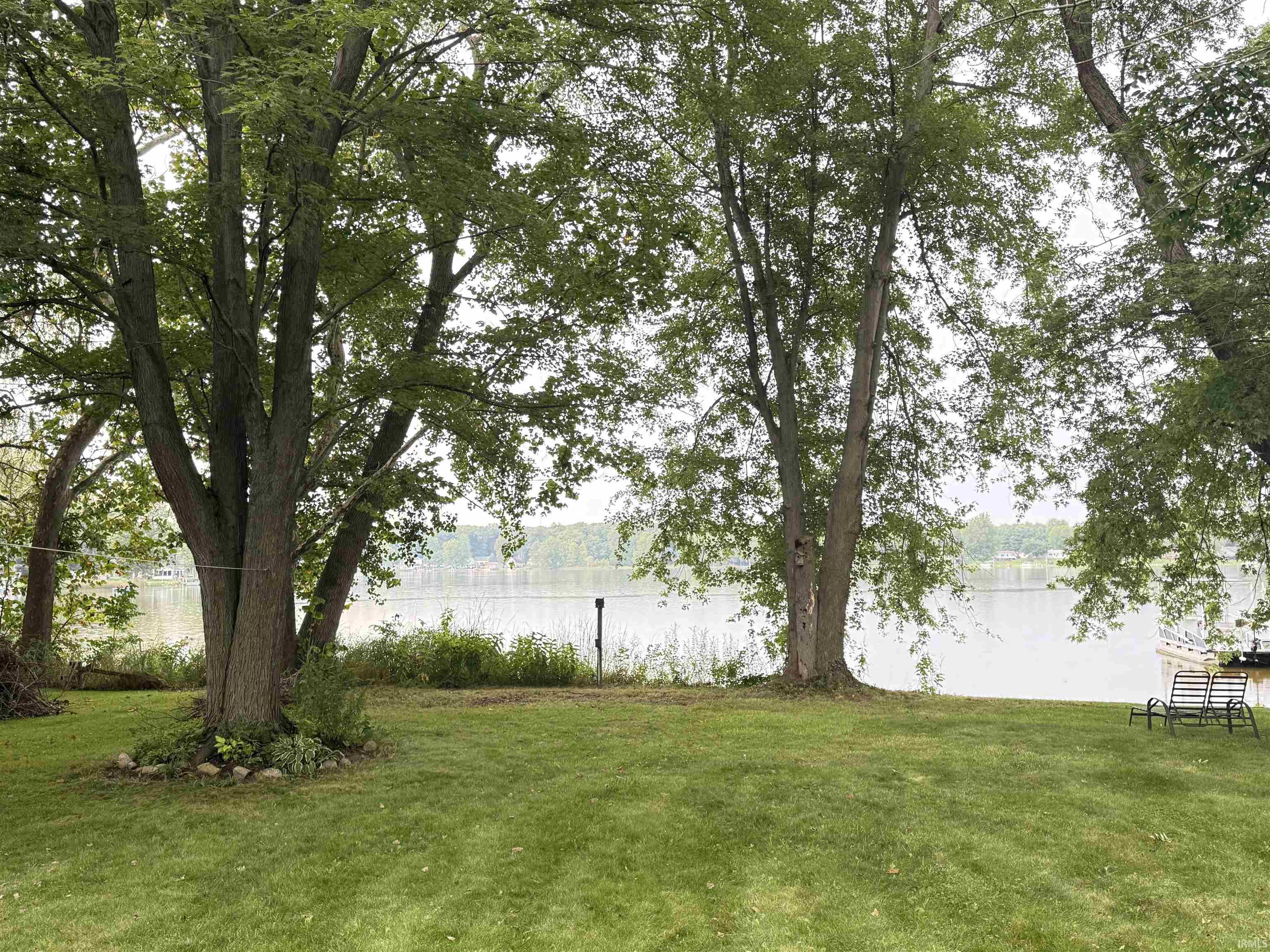 Manicured lawn with mature trees and waterfront access