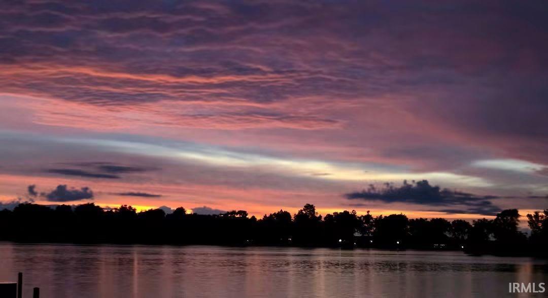 Waterfront setting with a tree-lined horizon and dramatic sky