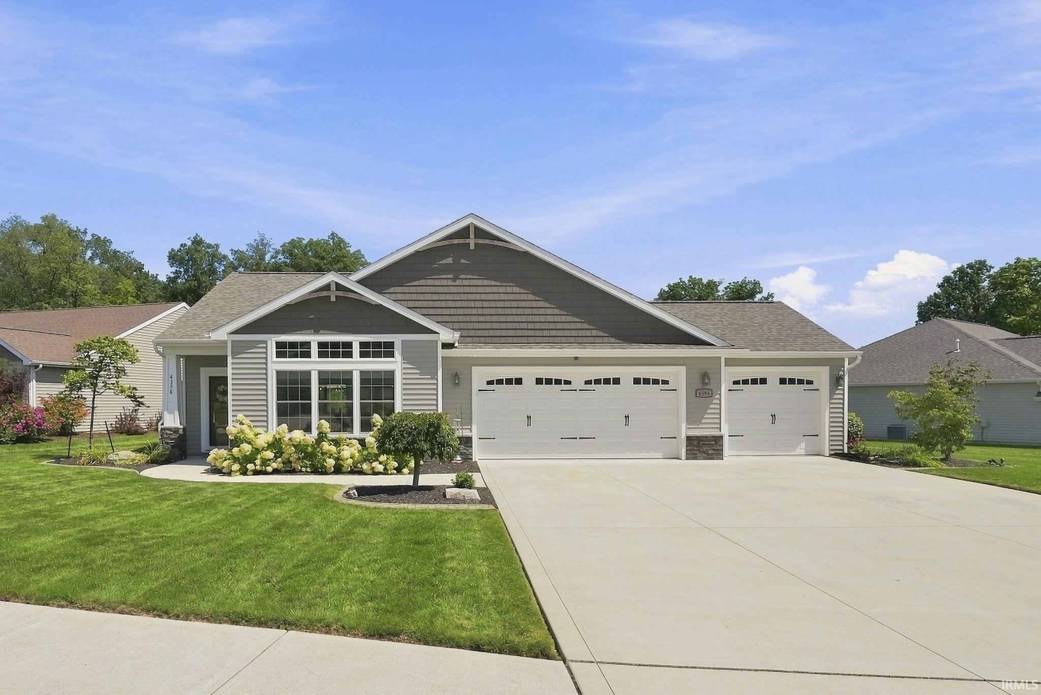Single-story residence featuring a combination of horizontal siding and shake siding, an attached two-car garage, concrete driveway, and front landscaping
