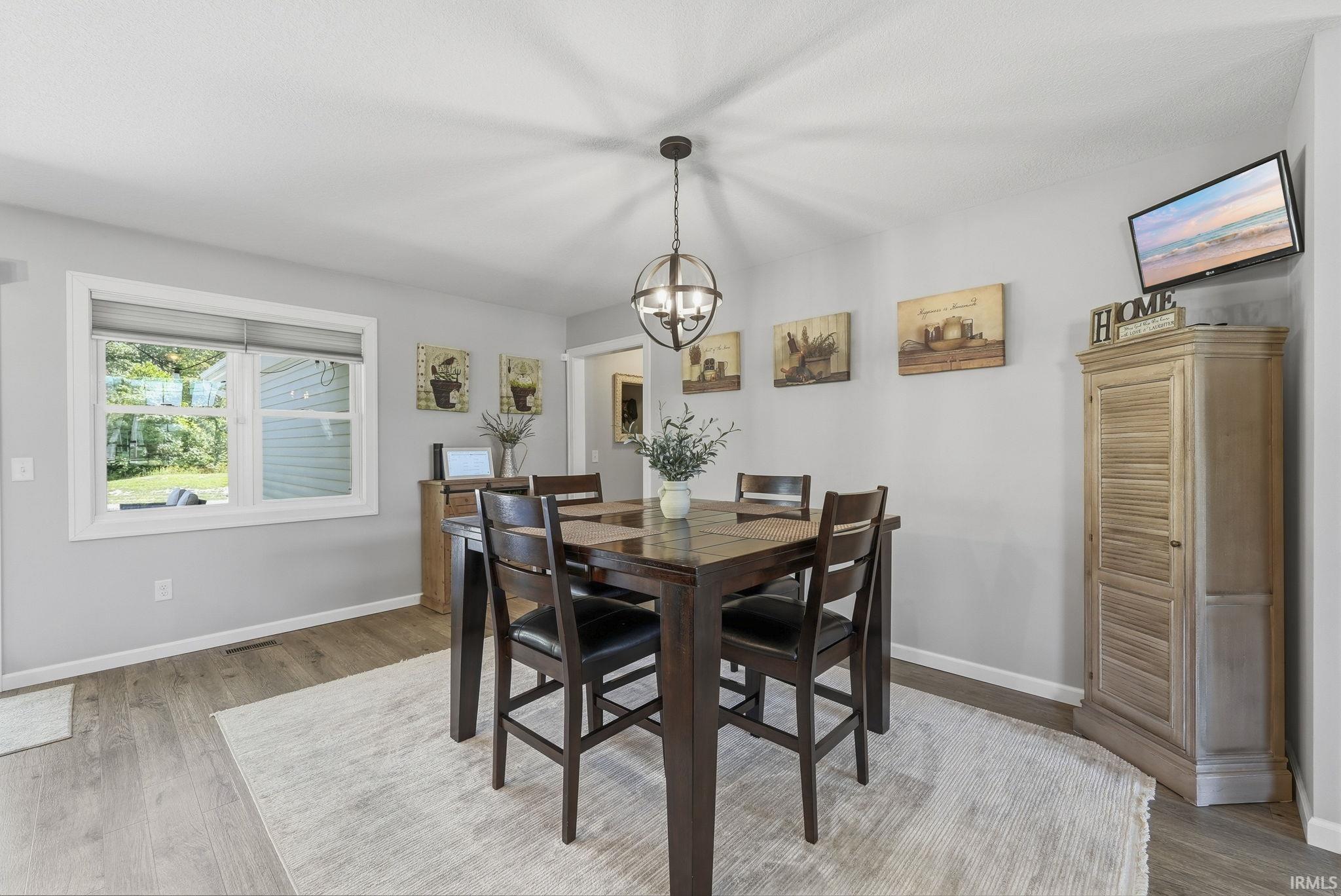 Recessed lighting and a contemporary chandelier illuminate this space