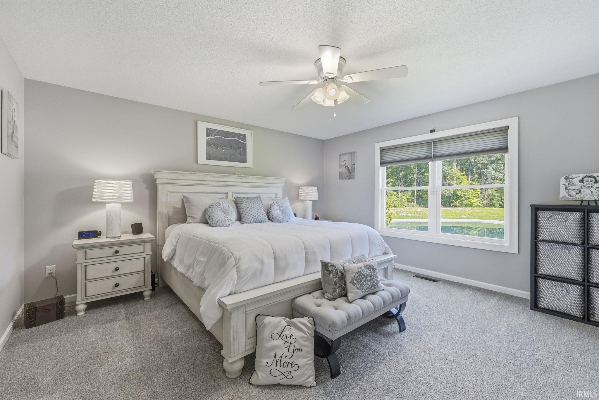 Carpeted room featuring a ceiling fan with integrated lighting, a window with horizontal blinds, and neutral wall tones