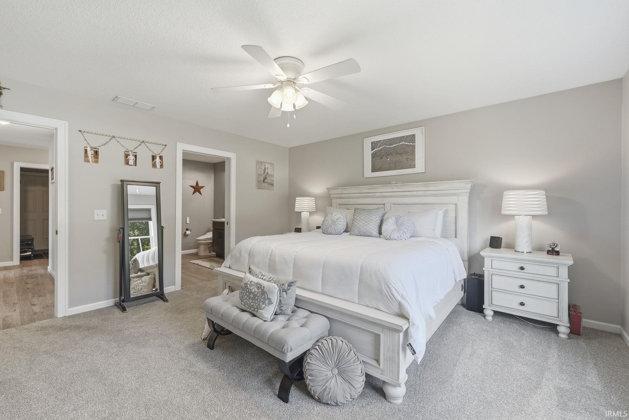 Spacious room featuring neutral carpeting, light-toned walls, and a ceiling fan