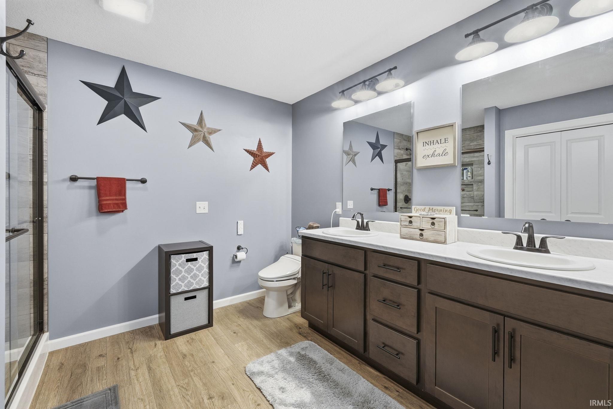 Bathroom featuring a dual vanity with dark wood-finish cabinetry, two undermount sinks, and individual mirrors