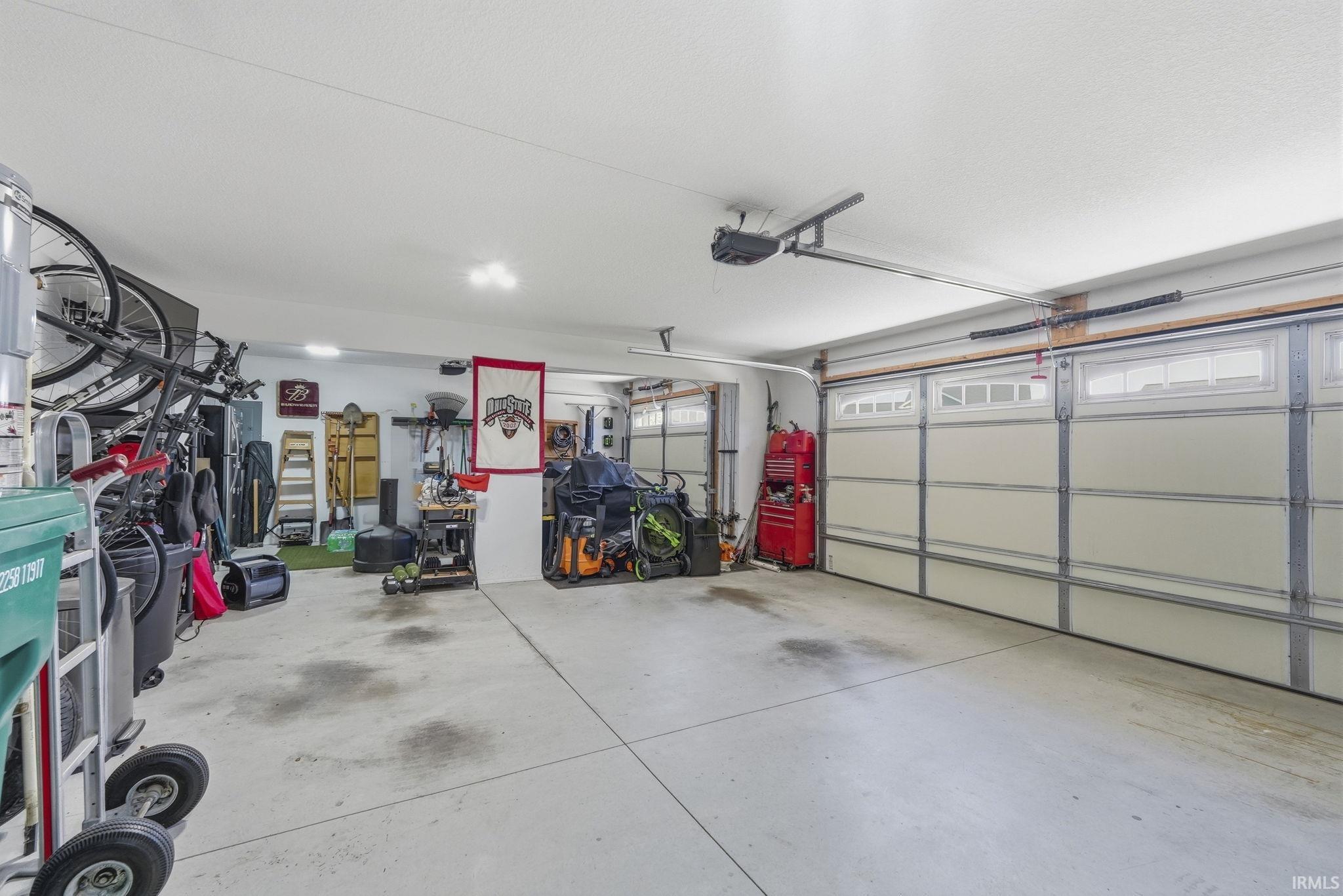 Attached two-car garage with concrete flooring and overhead lighting