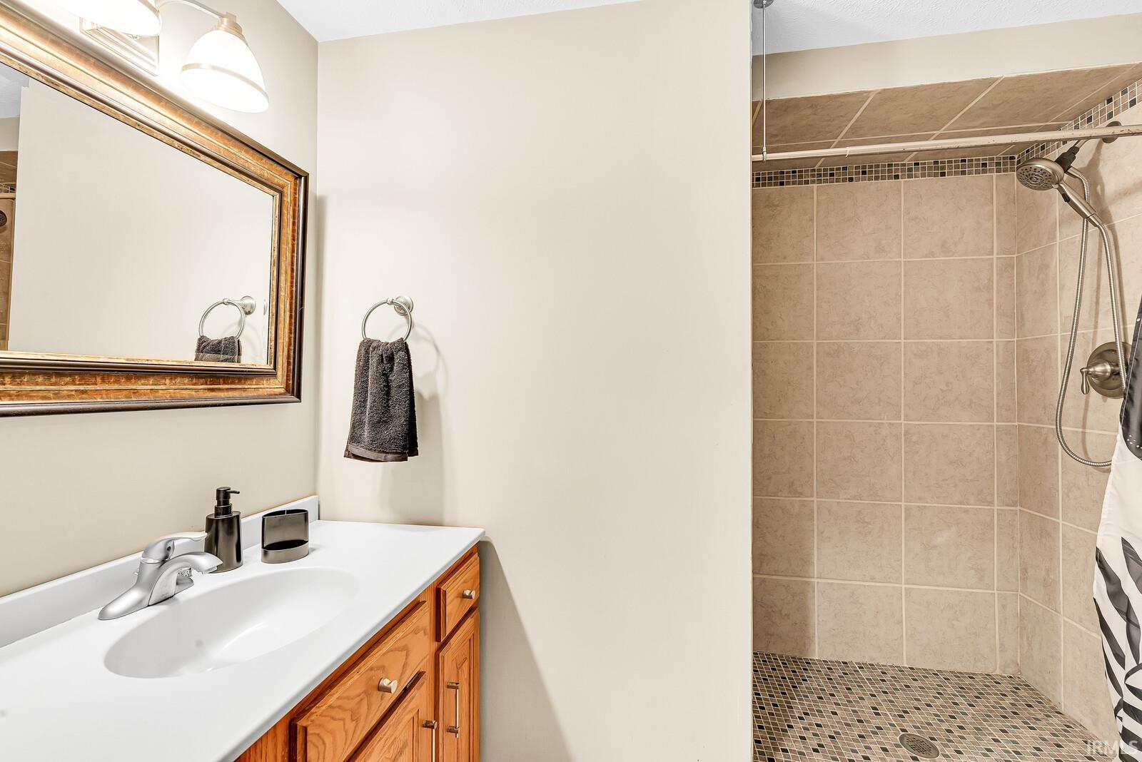 Vanity with a white countertop and wood-finish cabinetry