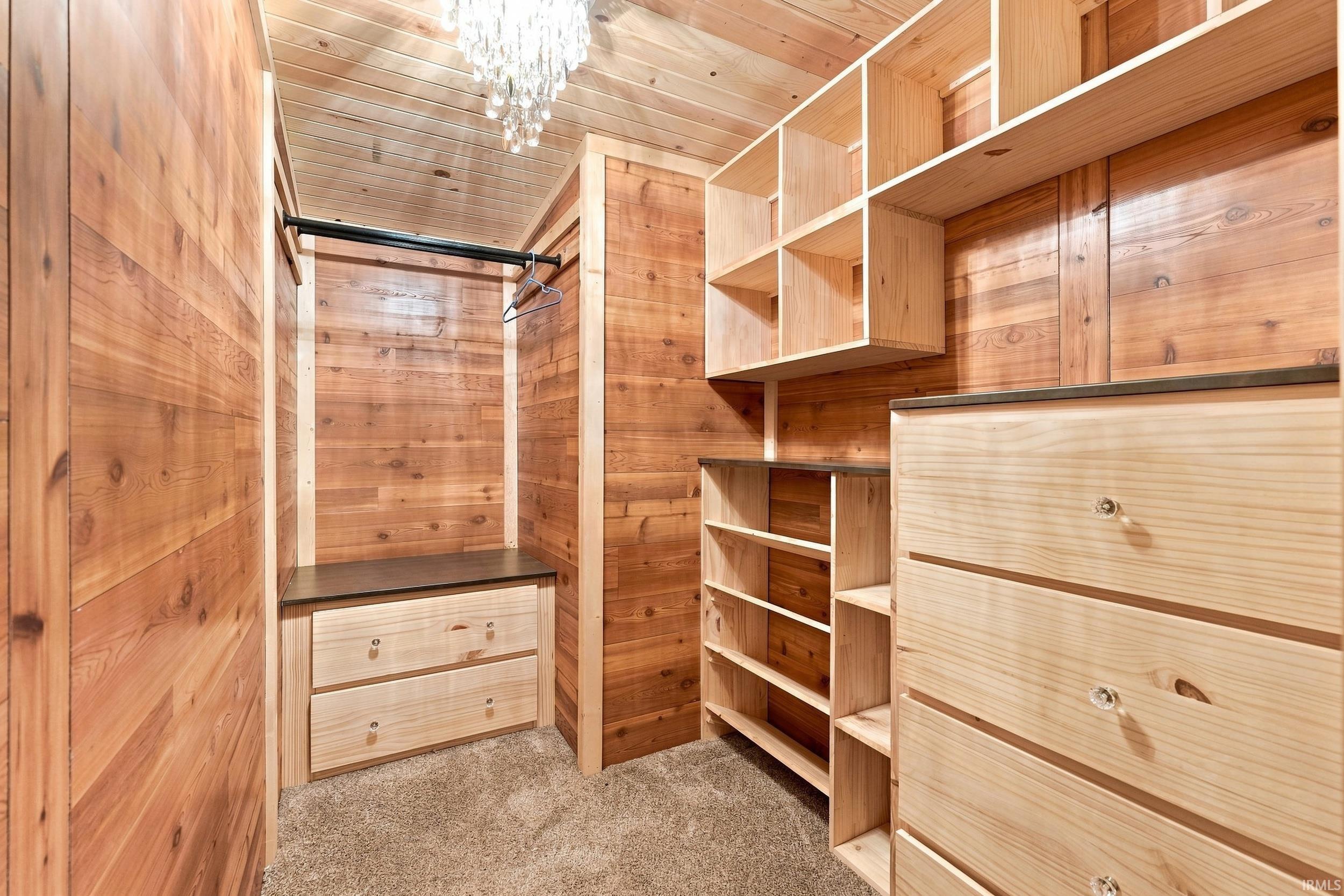 Custom built-in storage with light wood-finish drawers, integrated shelving, and hanging rod