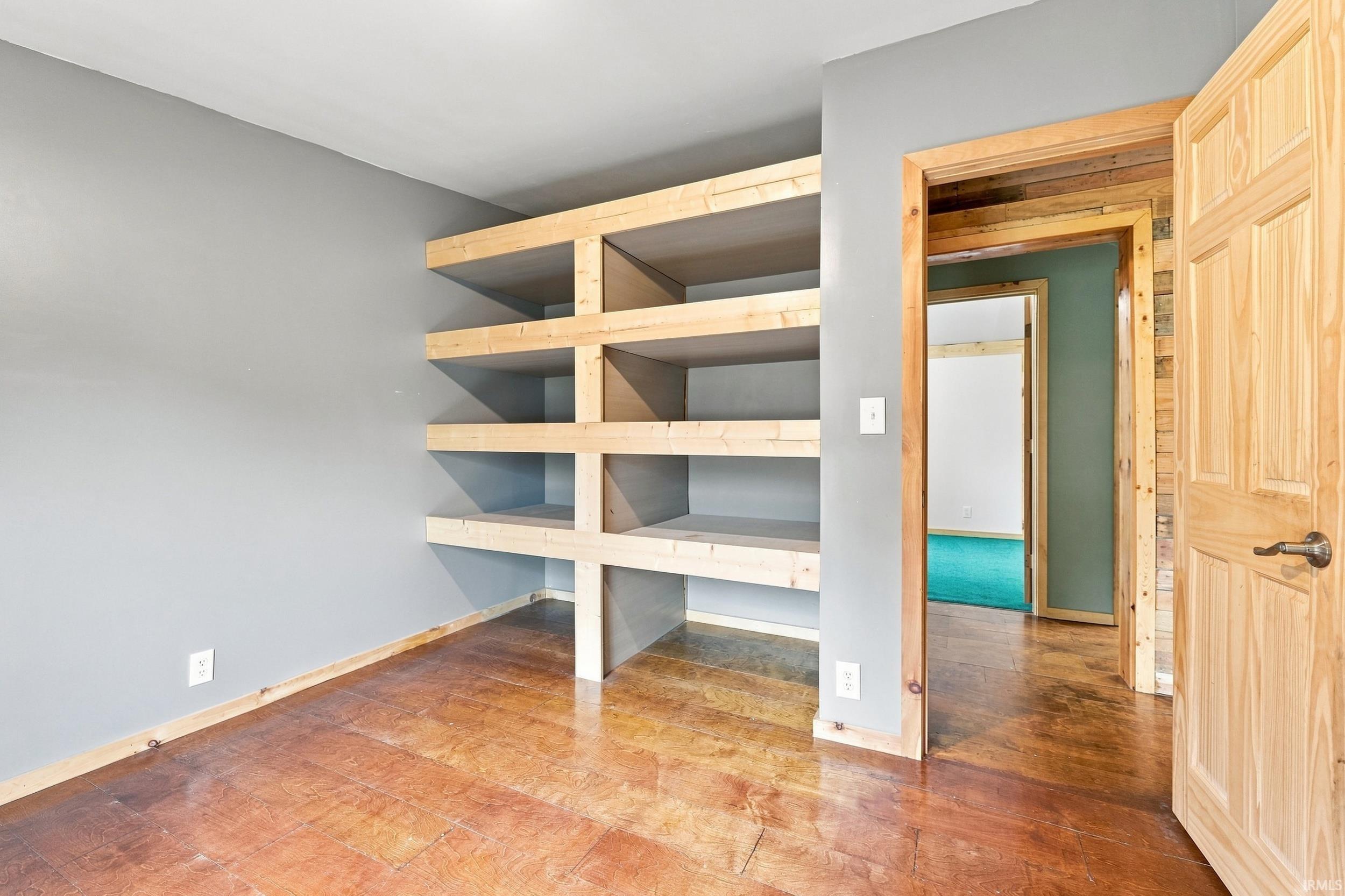 Custom built-in shelving, wood-finish flooring, and natural wood trim throughout