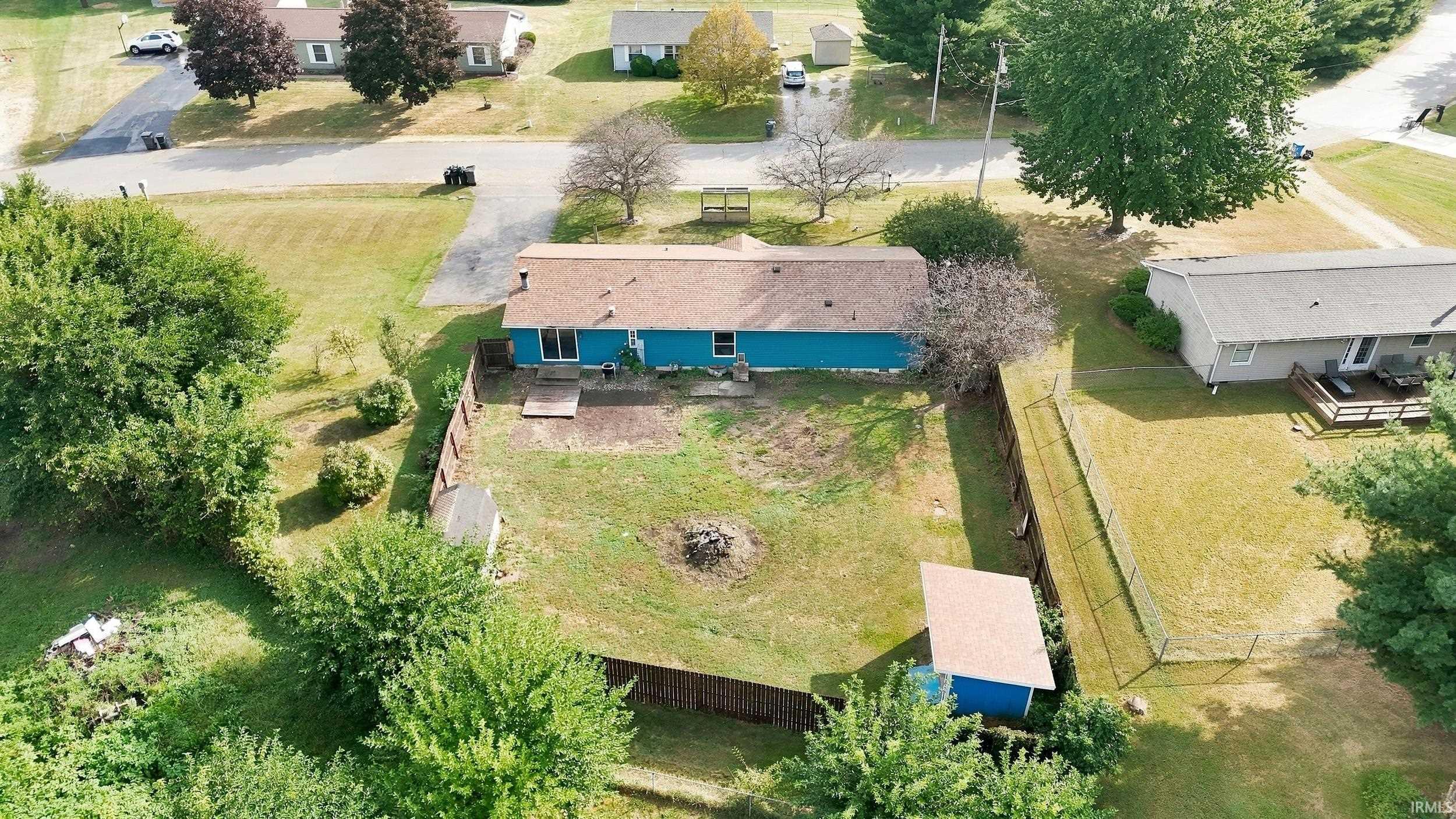 Fenced backyard featuring a detached shed and a ground-level patio