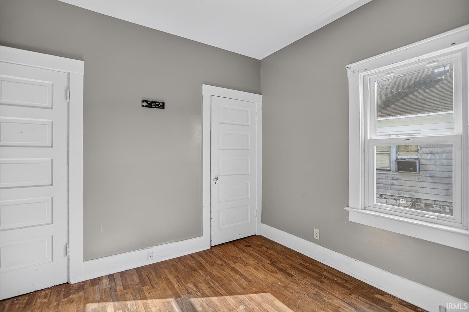 Hardwood floor, window, closet and door to attic stairway