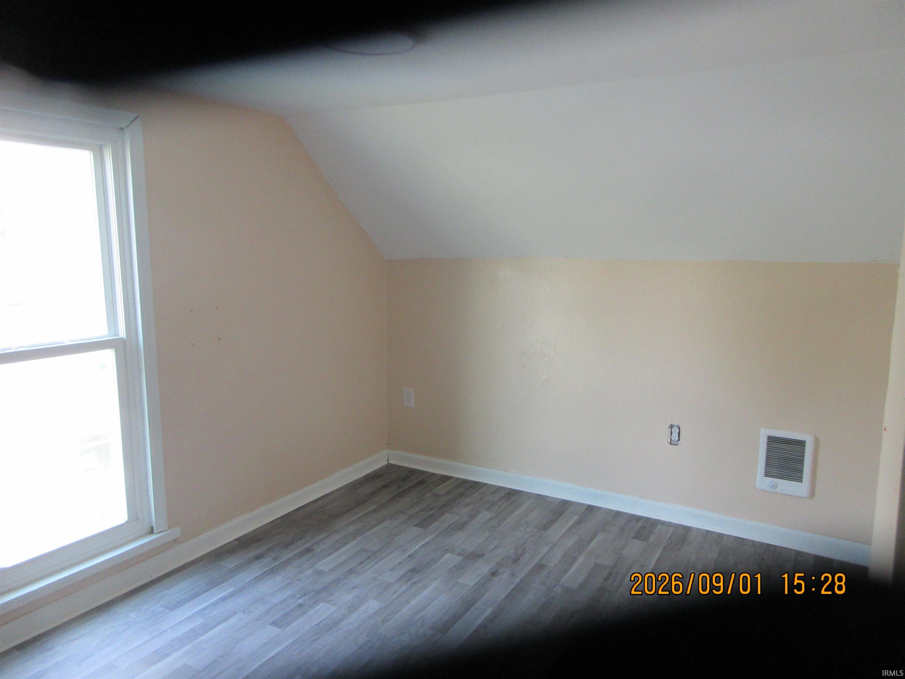 Window with white trim and wood-finish flooring