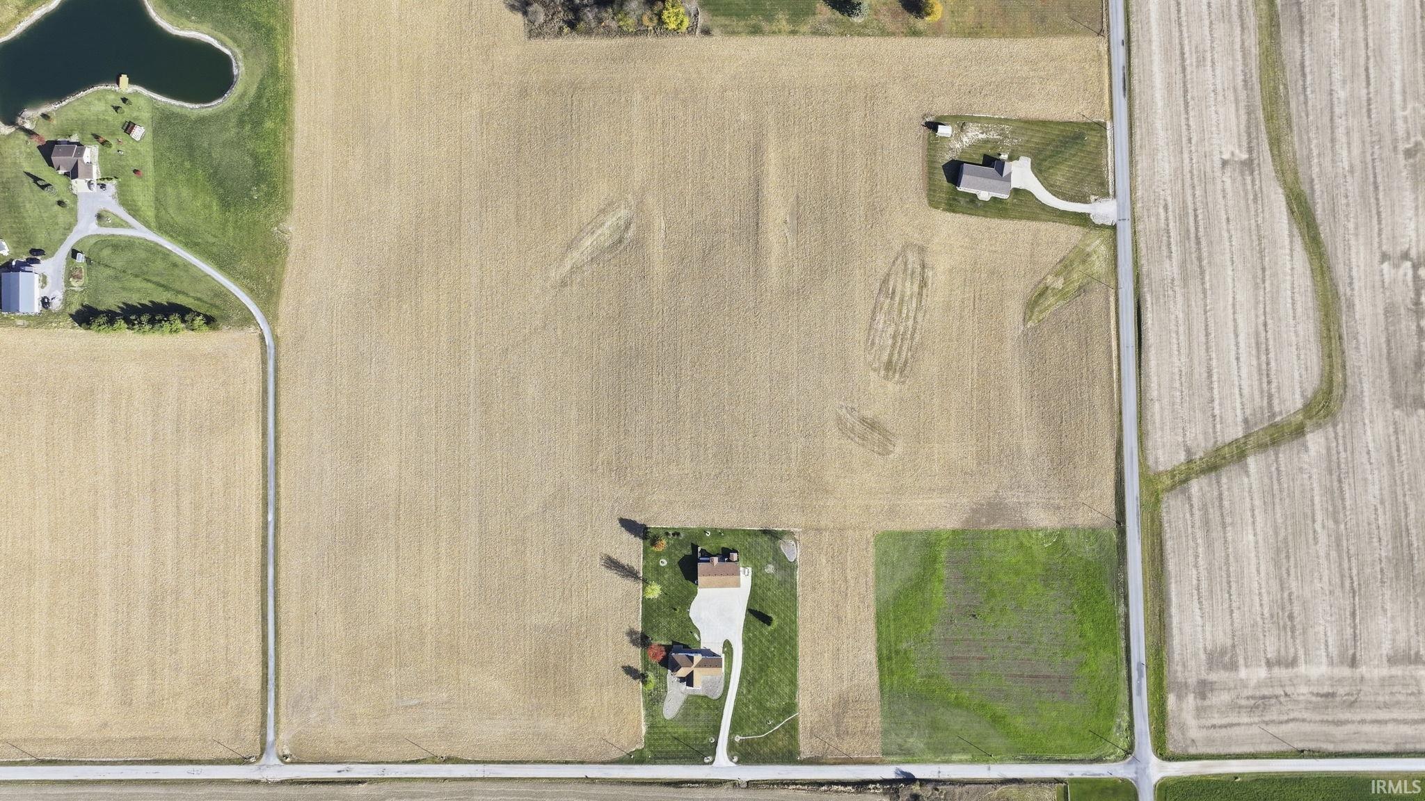 Expansive acreage featuring cleared land, paved driveway access, and mature perimeter vegetation