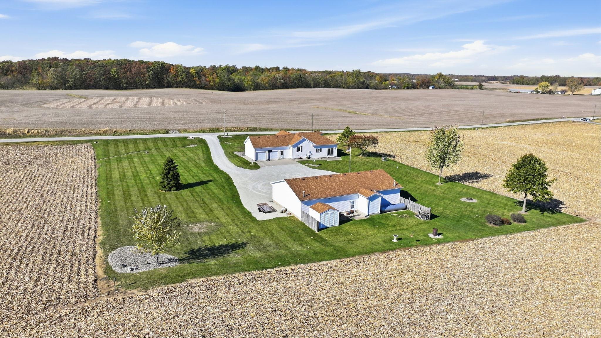 Expansive lot featuring a single-story residence, detached garage, paved driveway, and manicured lawn
