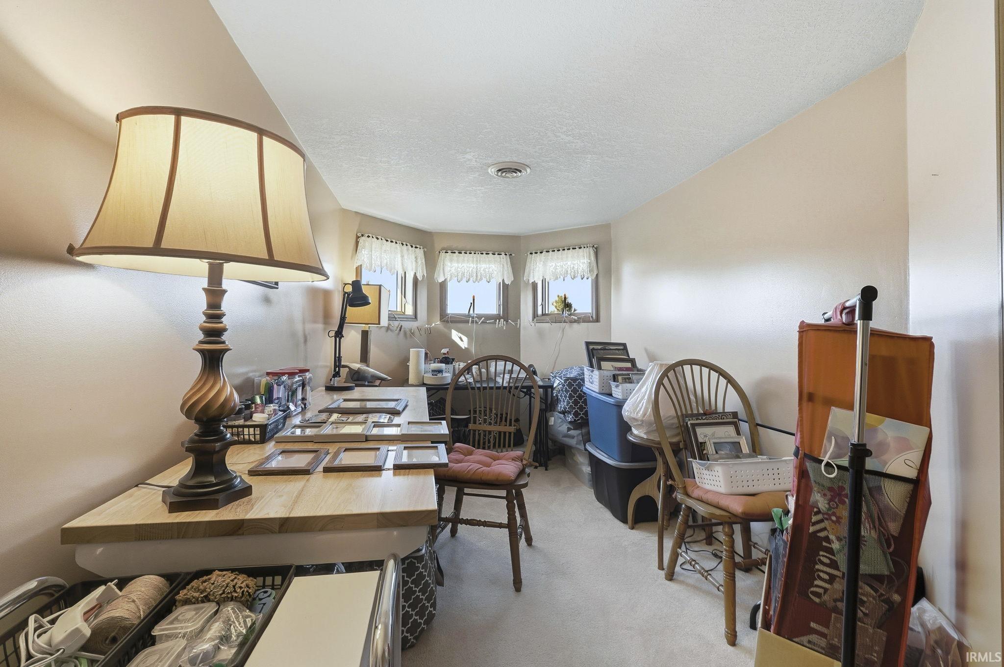 Room featuring a bay window assembly with three individual windows and neutral wall coloring