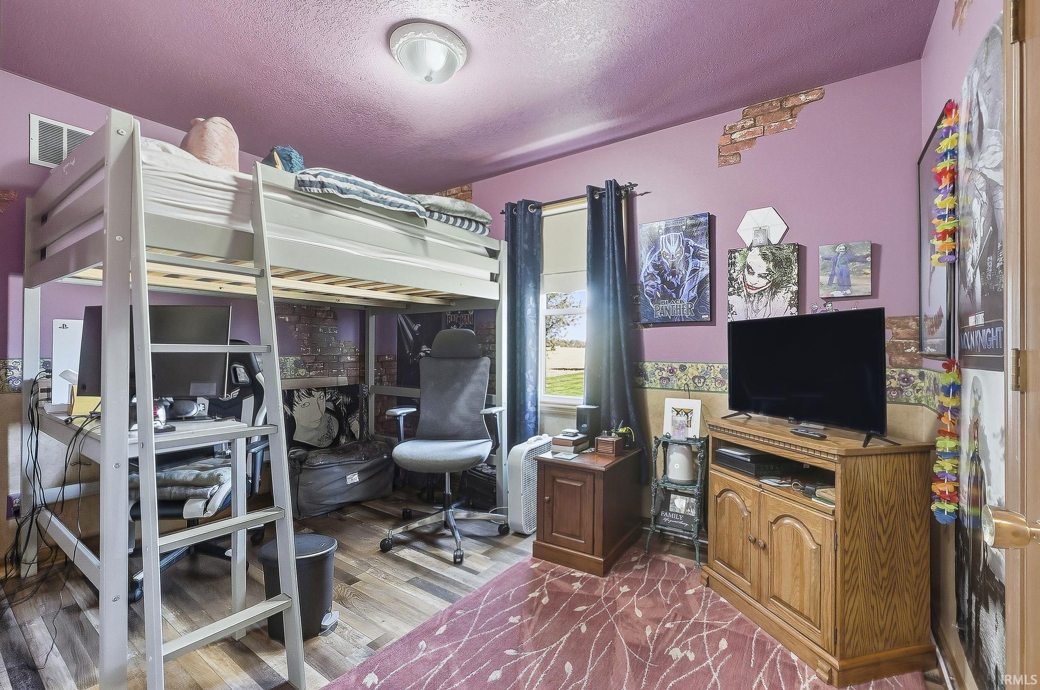 Bedroom featuring wood-finish flooring, a single window, and a flush-mount ceiling light fixture
