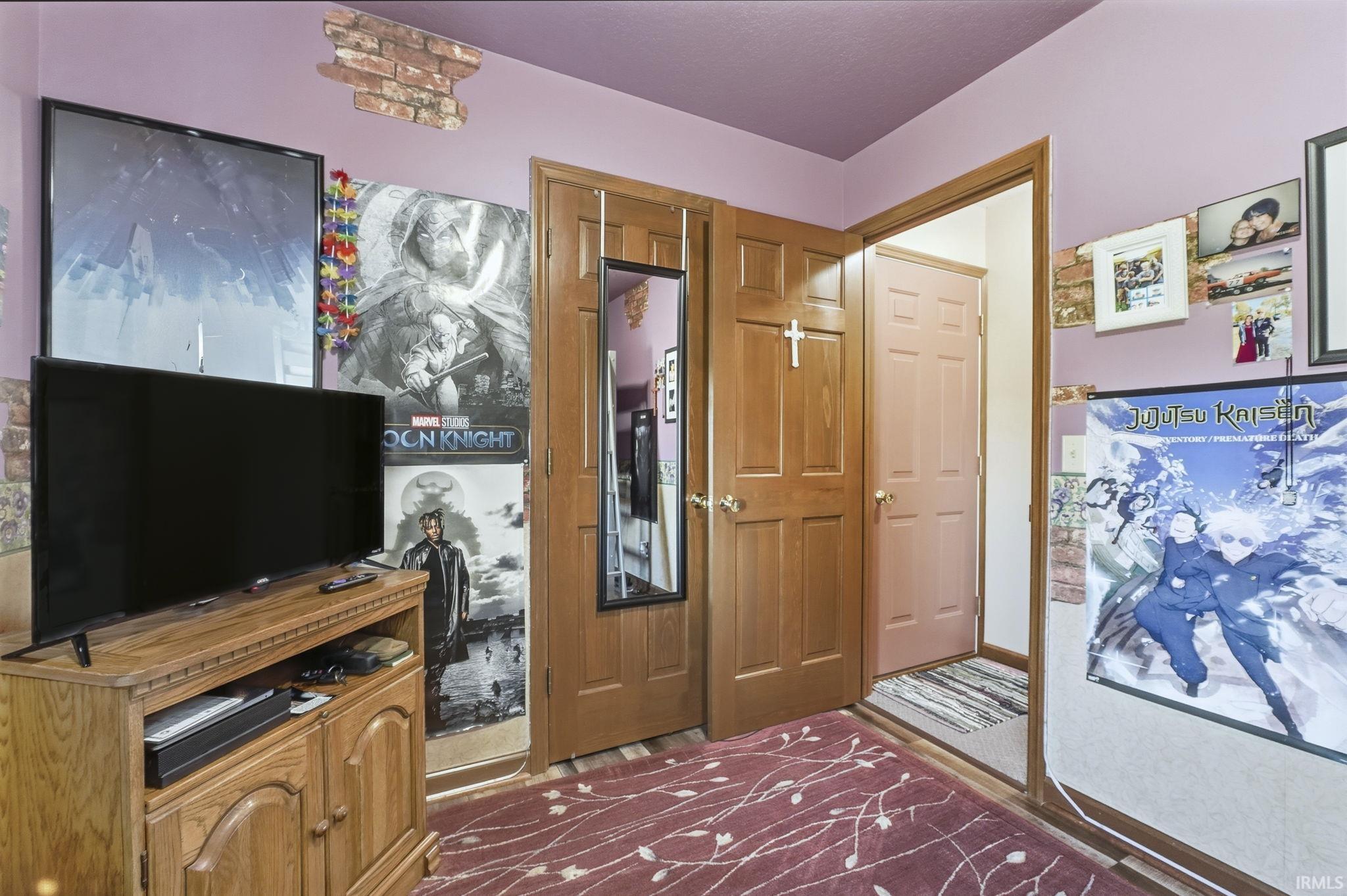 Interior space featuring six-panel wood doors, brick-texture wall accents, and neutral carpeting