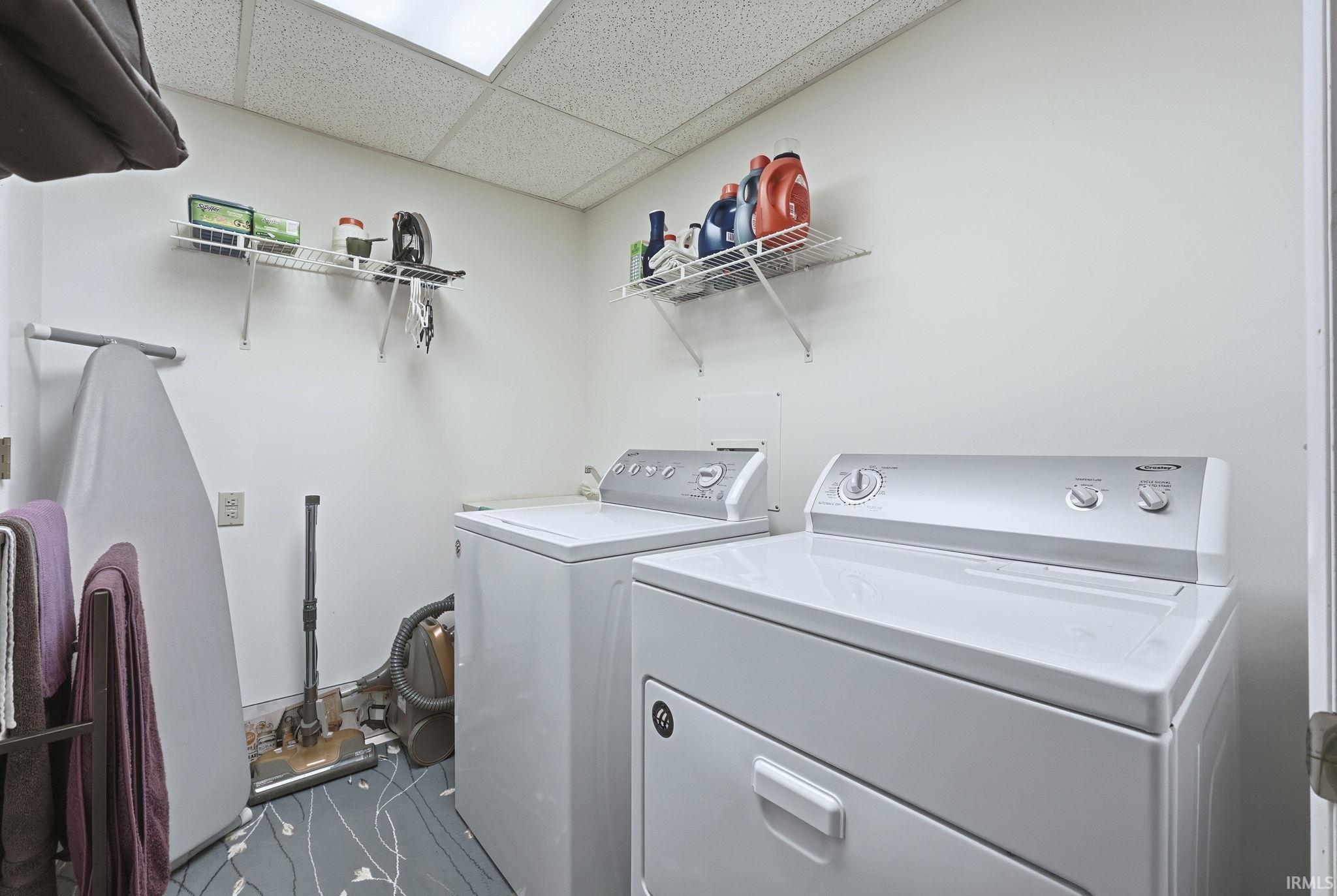 Laundry area featuring dual wall-mounted wire storage shelving and patterned flooring