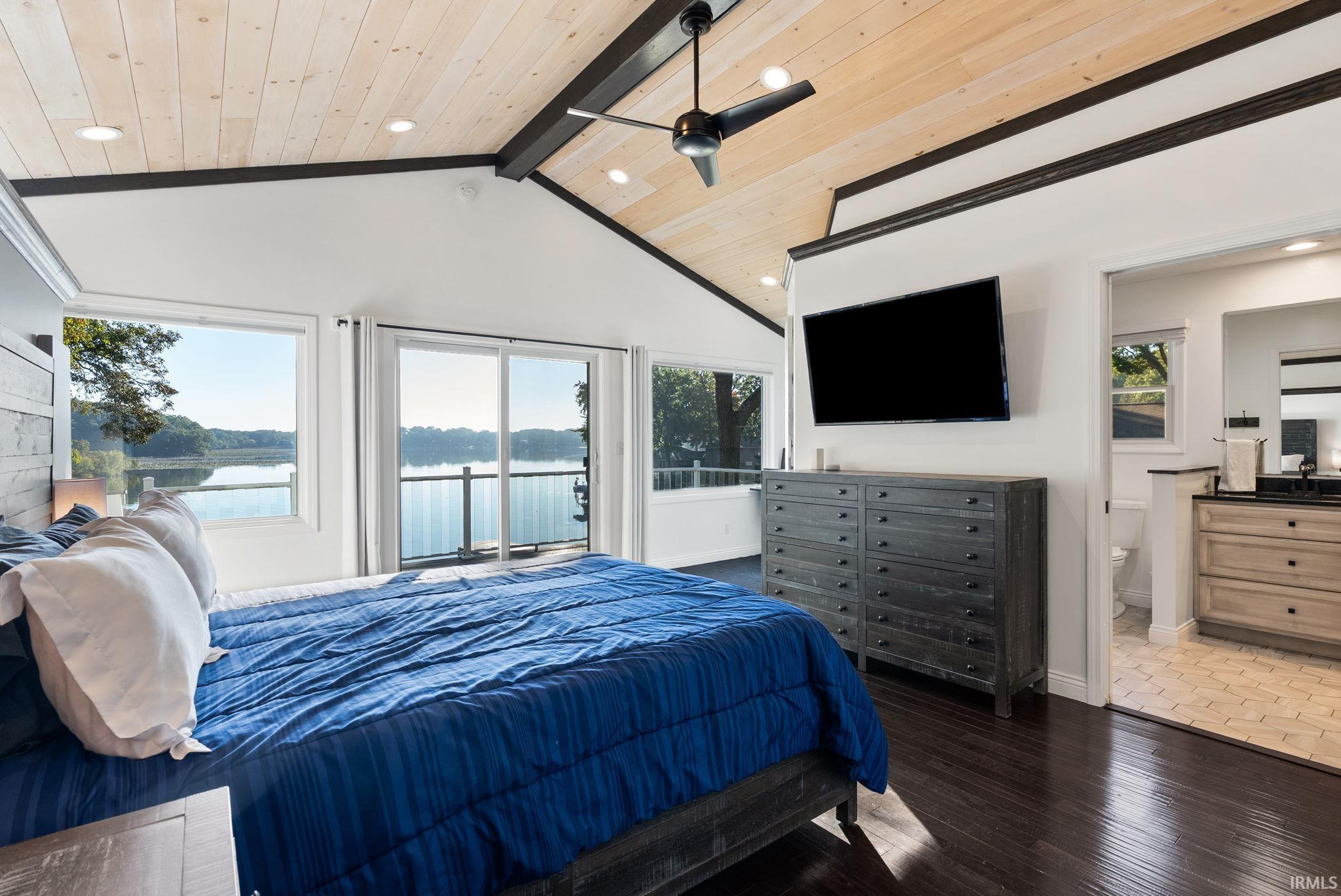 Vaulted wood-paneled ceiling with exposed beams, recessed lighting, and a ceiling fan