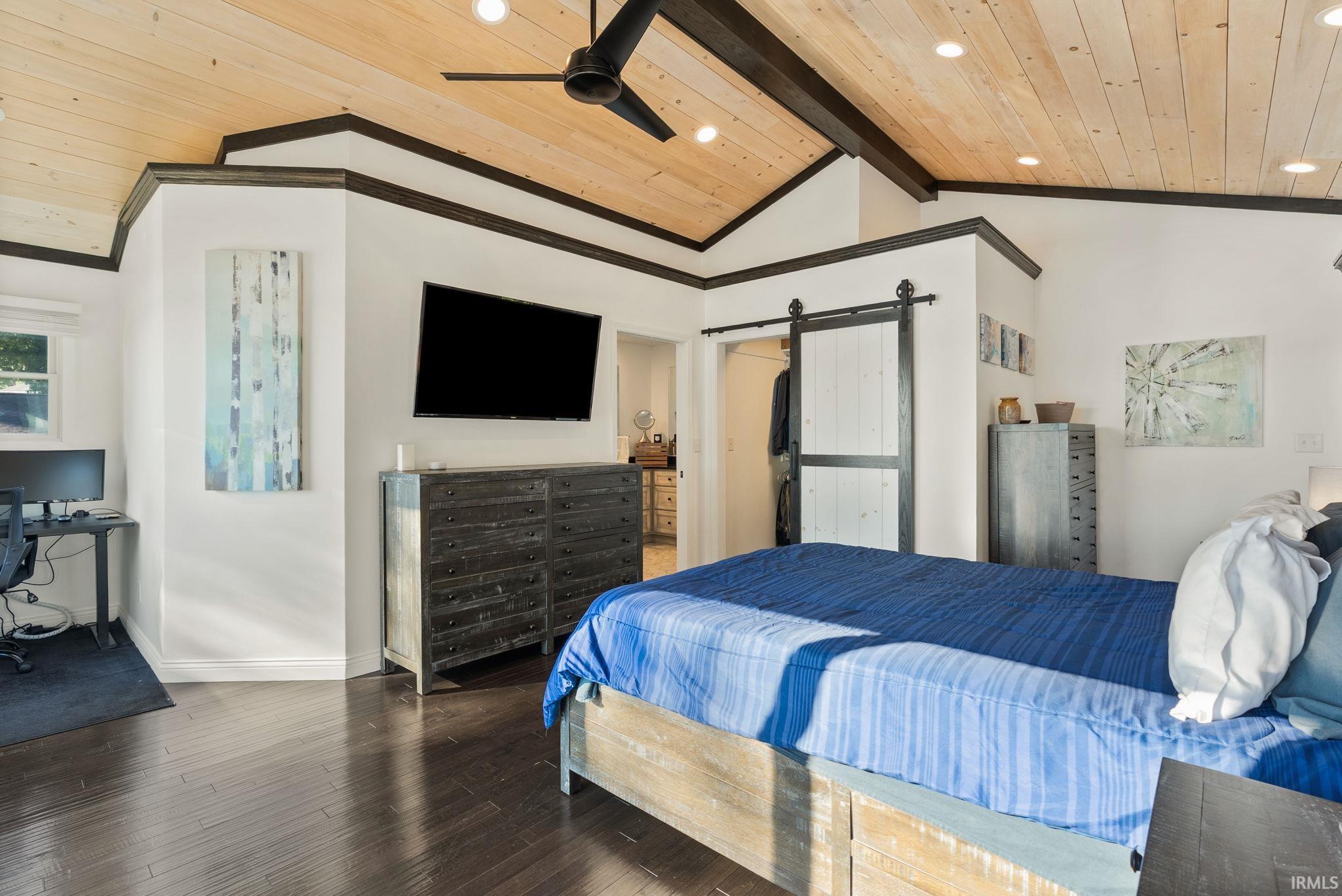 Wood-finish flooring throughout, featuring a vaulted wood-paneled ceiling with recessed lighting and a black ceiling fan