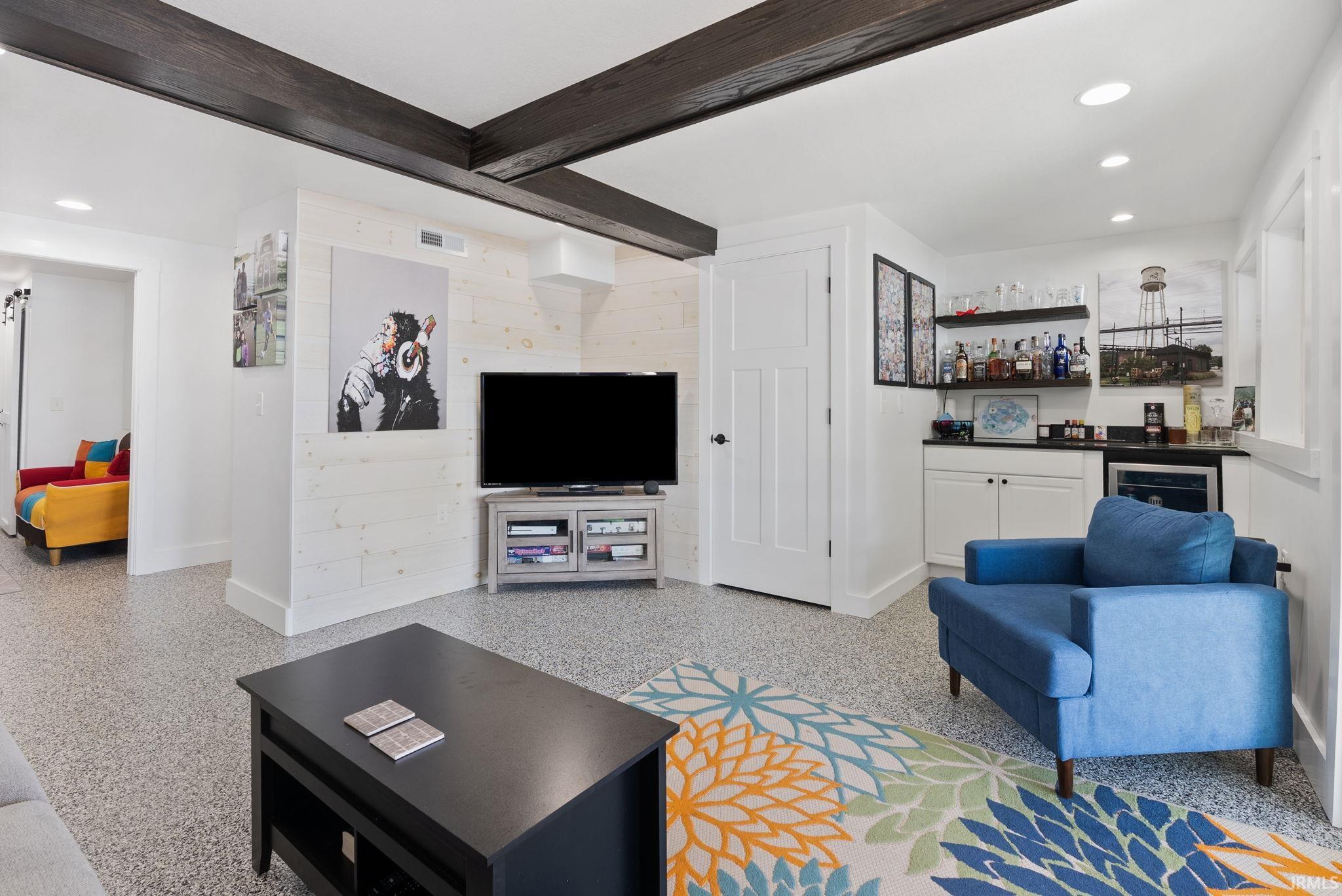 Recessed lighting, exposed wood beams, built-in wet bar with cabinetry, built-in beverage cooler, and wood-finish flooring