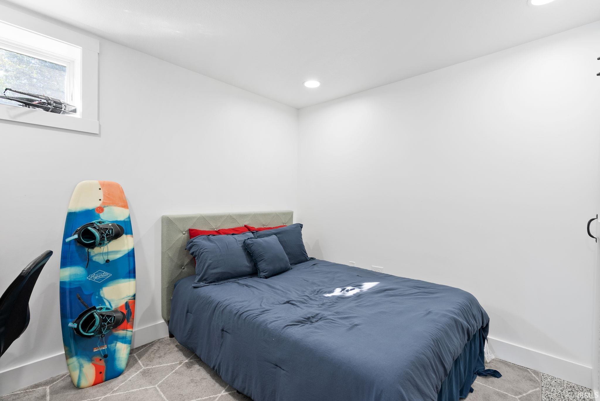 Recessed lighting, window with white trim, white walls, geometric patterned flooring