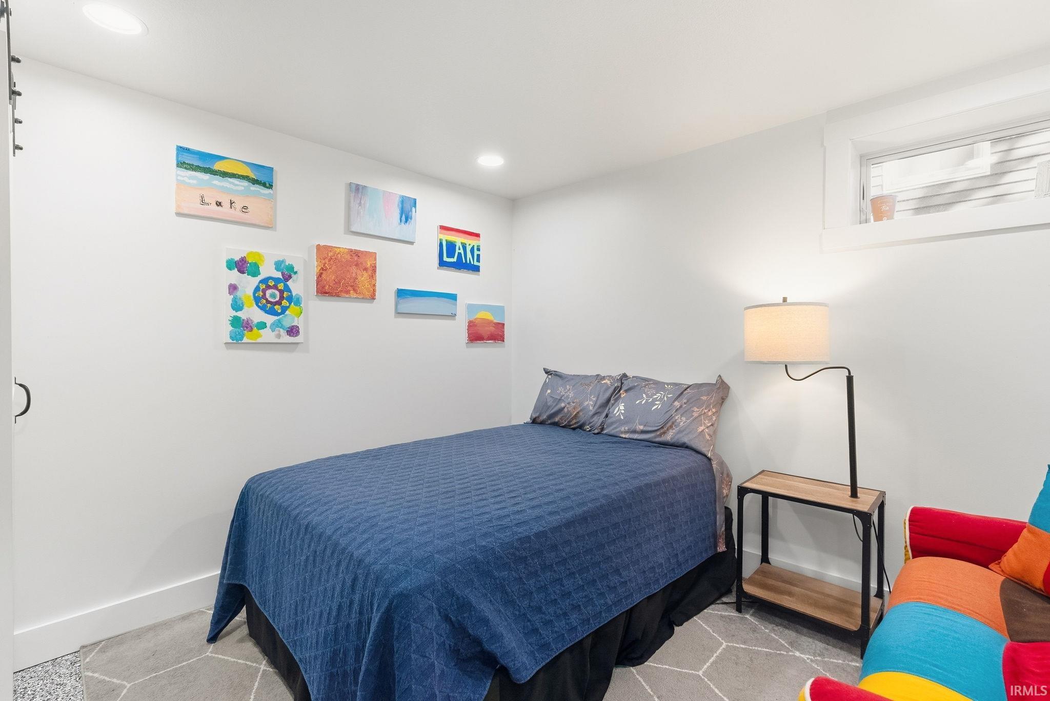 Recessed ceiling lighting, white walls, and a window with white trim