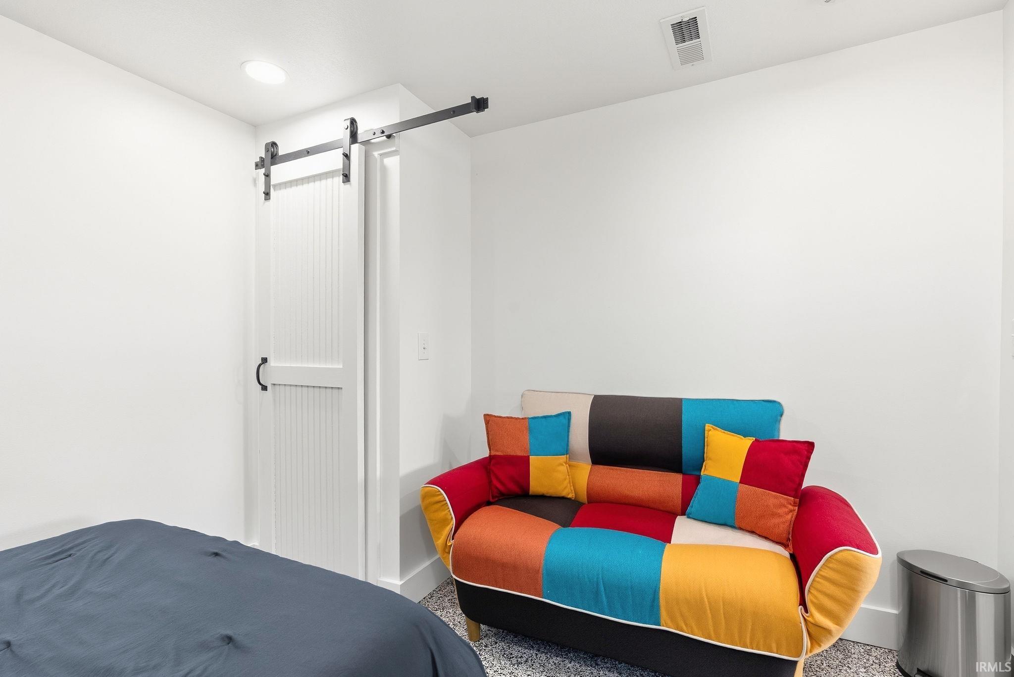 Recessed lighting, barn door hardware, and a white paneled door