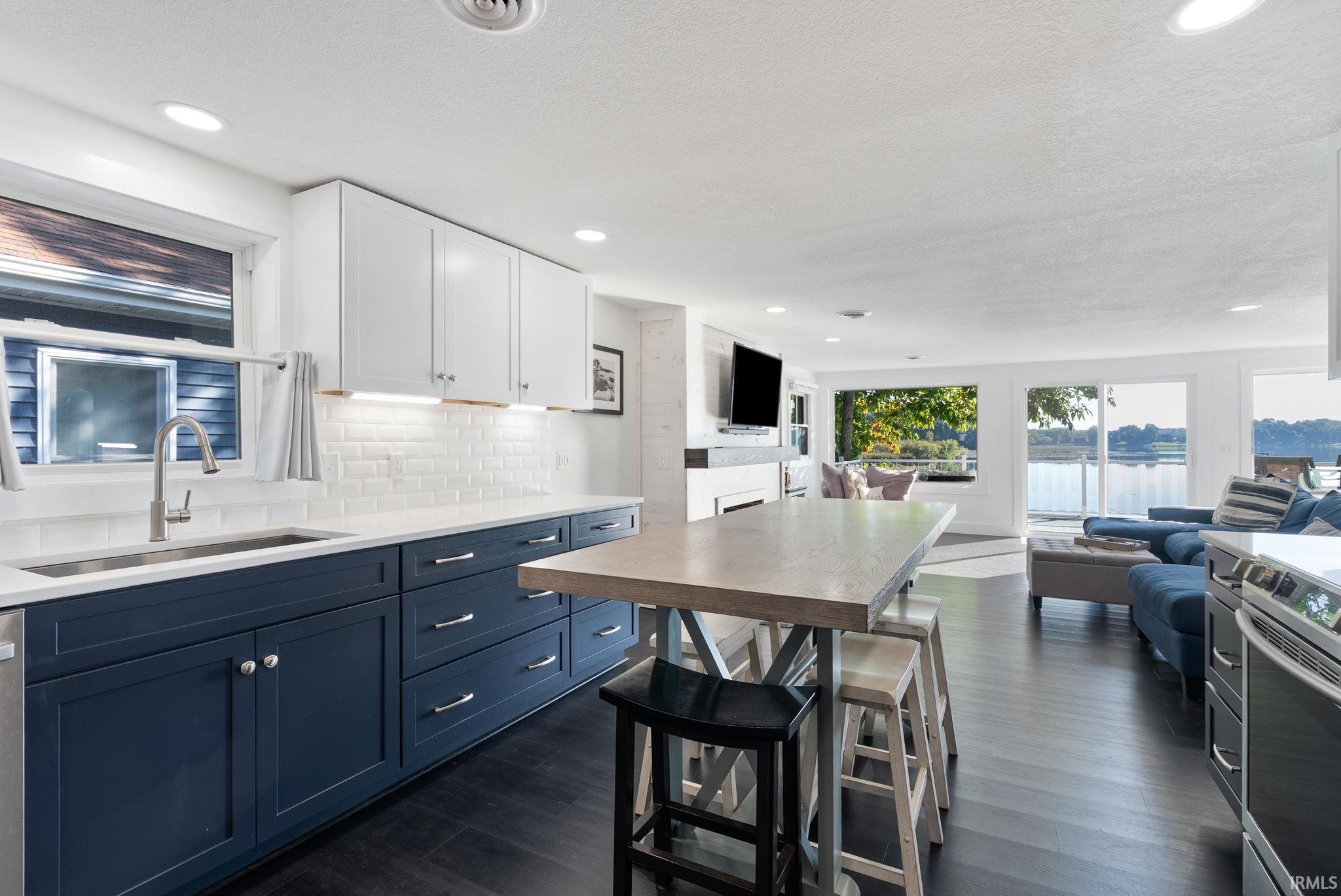 Open concept interior featuring wood-finish flooring, recessed lighting, and white subway tile backsplash