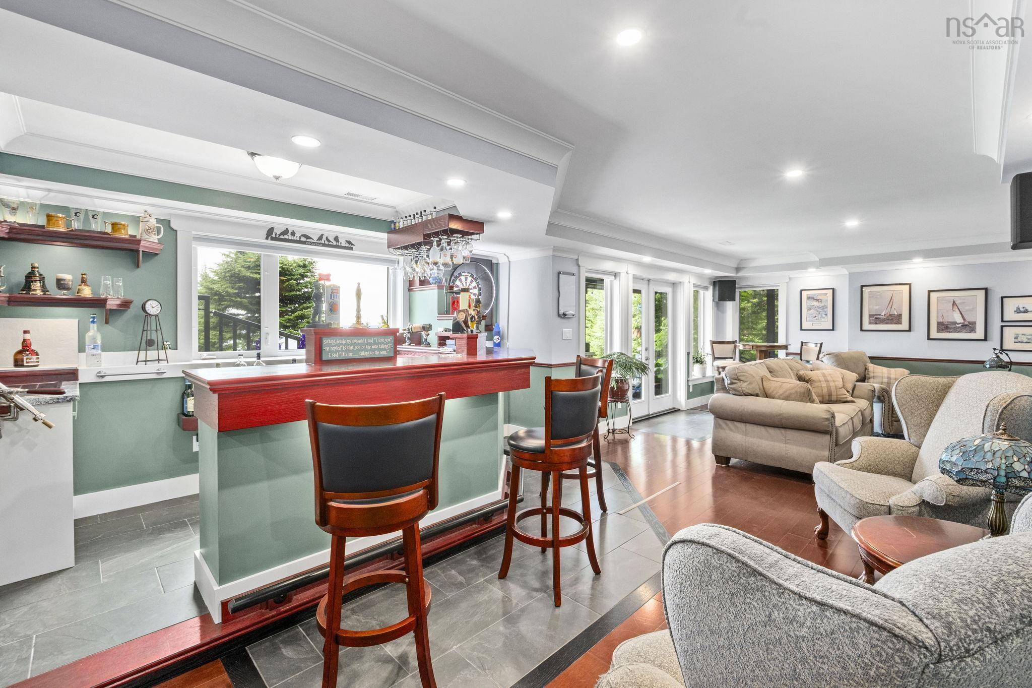 116 Whitecap Ridge, Black Point, NS (MLS® 202618413) — Integrated wet bar featuring a red wood-finish countertop, under-cabinet lighting, and grey tile flooring