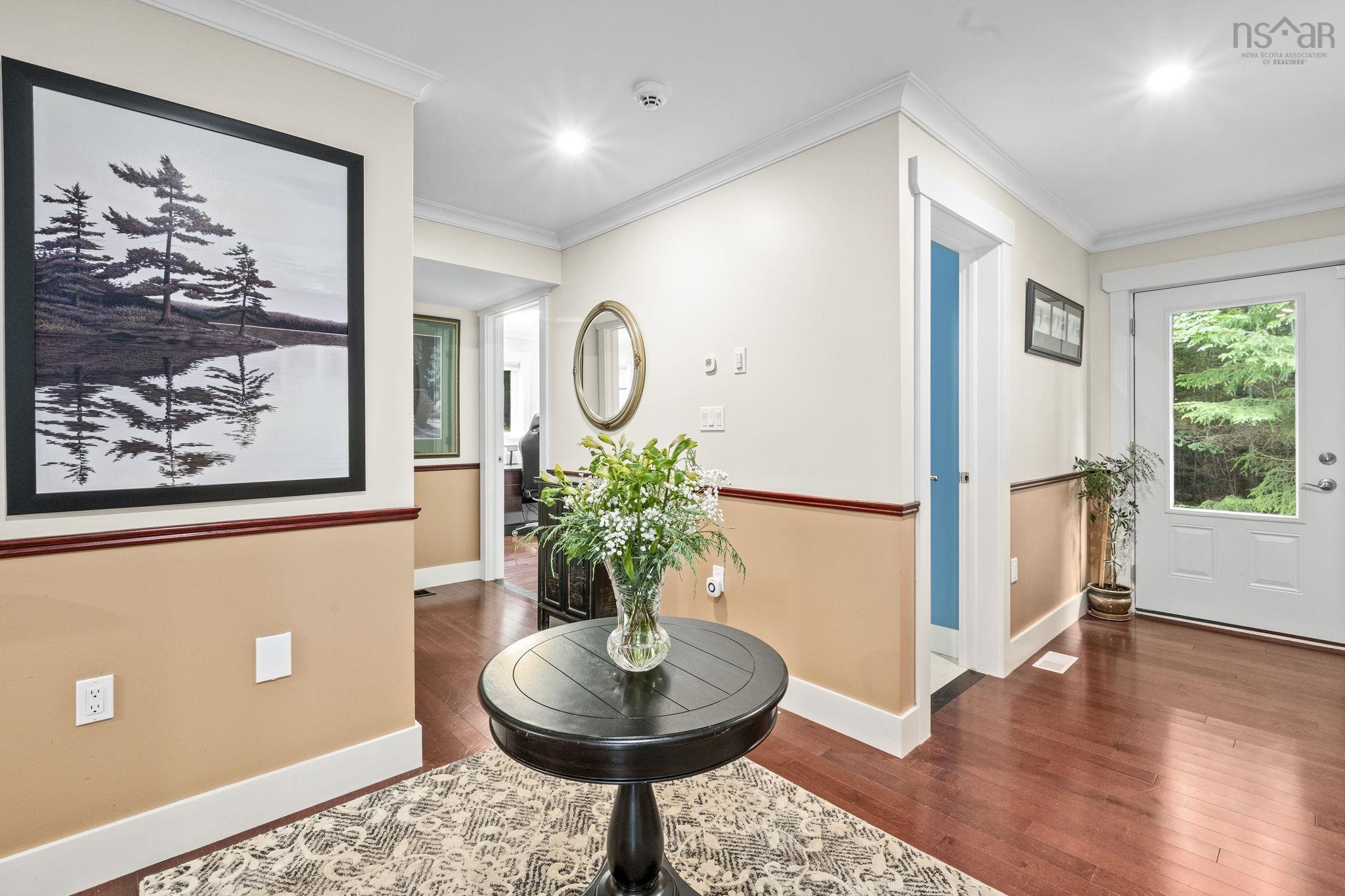 116 Whitecap Ridge, Black Point, NS (MLS® 202618413) — Entryway featuring wood-finish flooring, two-tone wall treatment with dark trim, recessed ceiling lighting, and a white exterior door with glass paneling